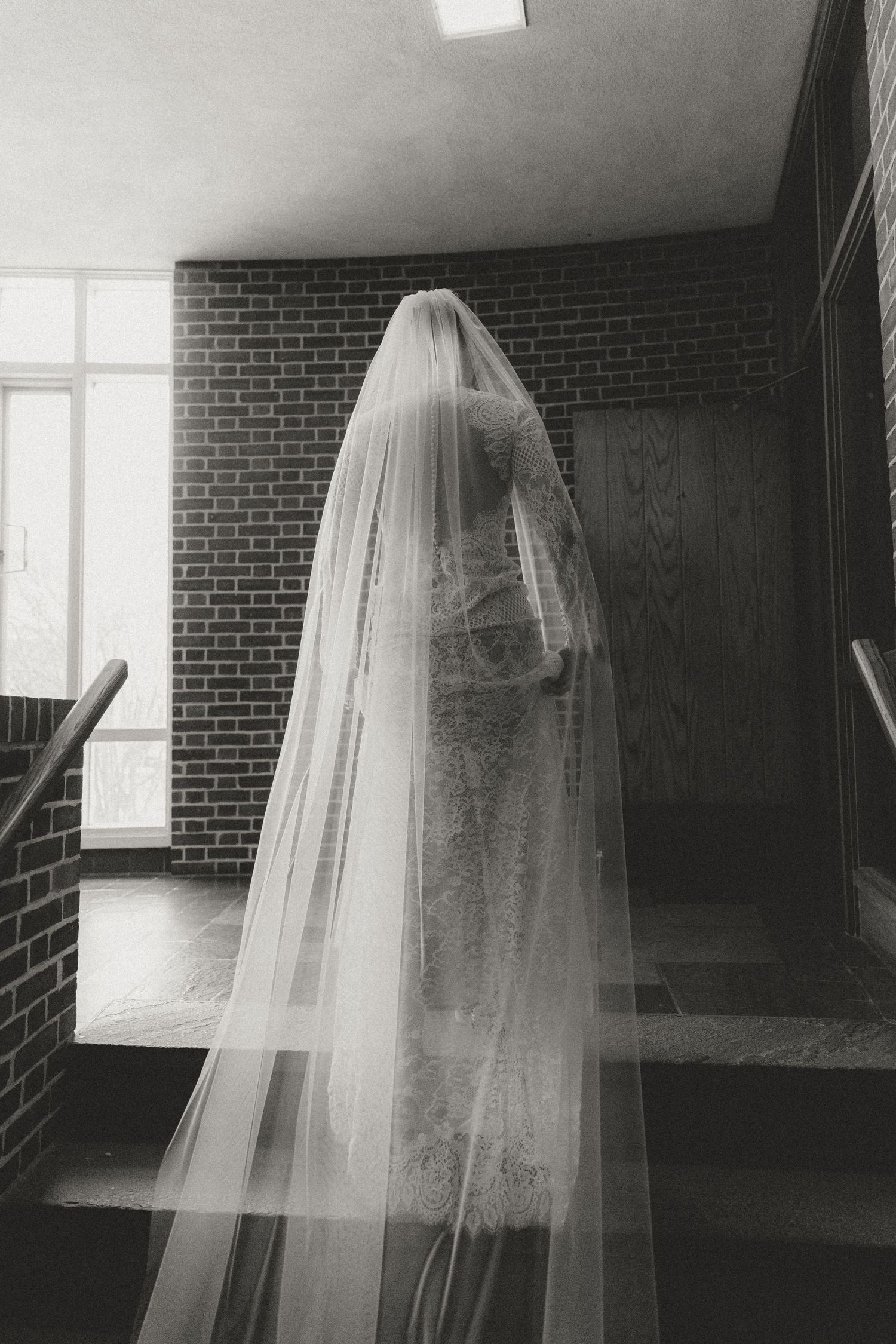 Ethereal bridal veil floating in an empty brick-walled room with natural light.