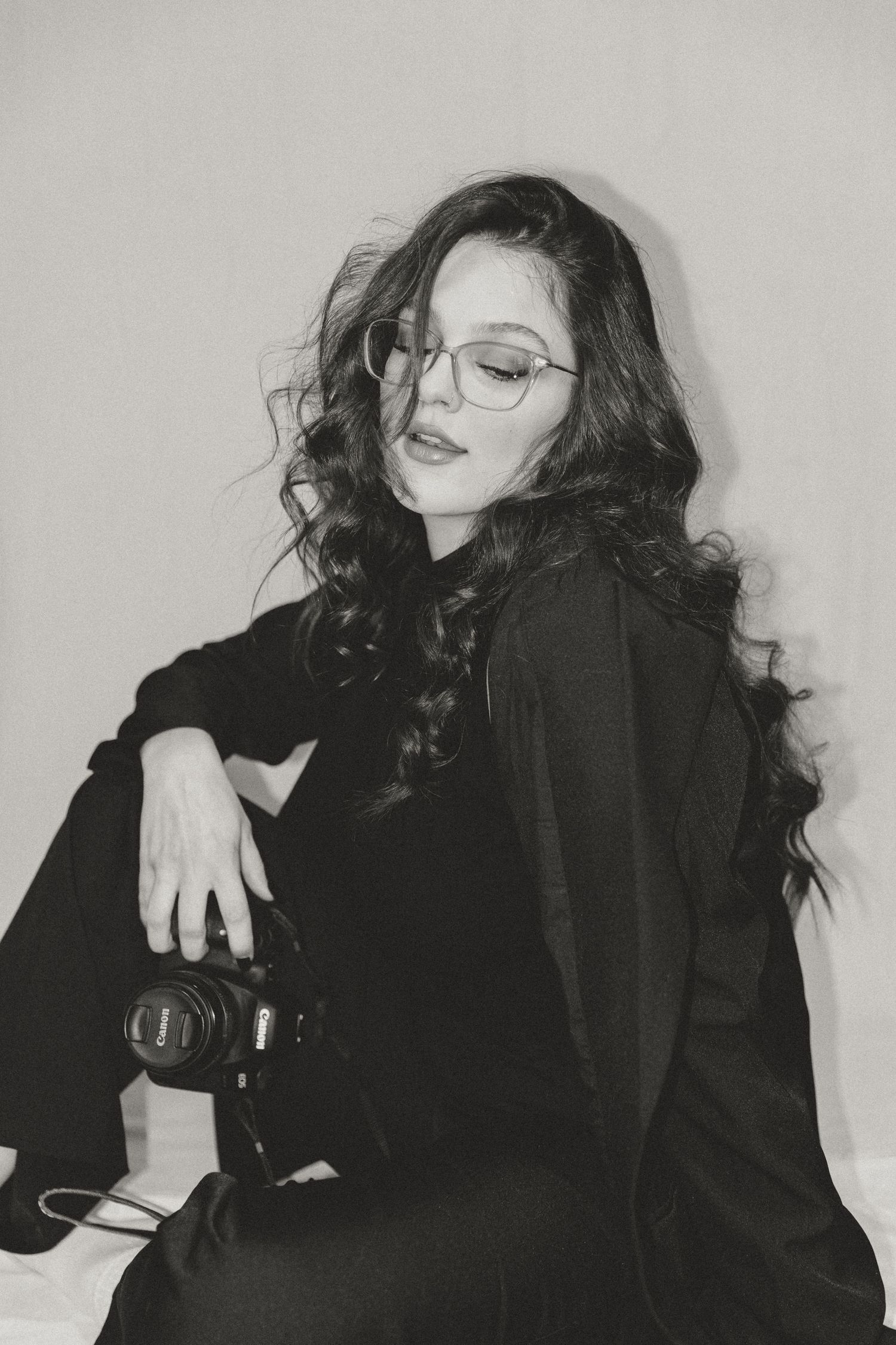 A series of moody black and white fashion portraits showing a person in dark clothing against a light background.