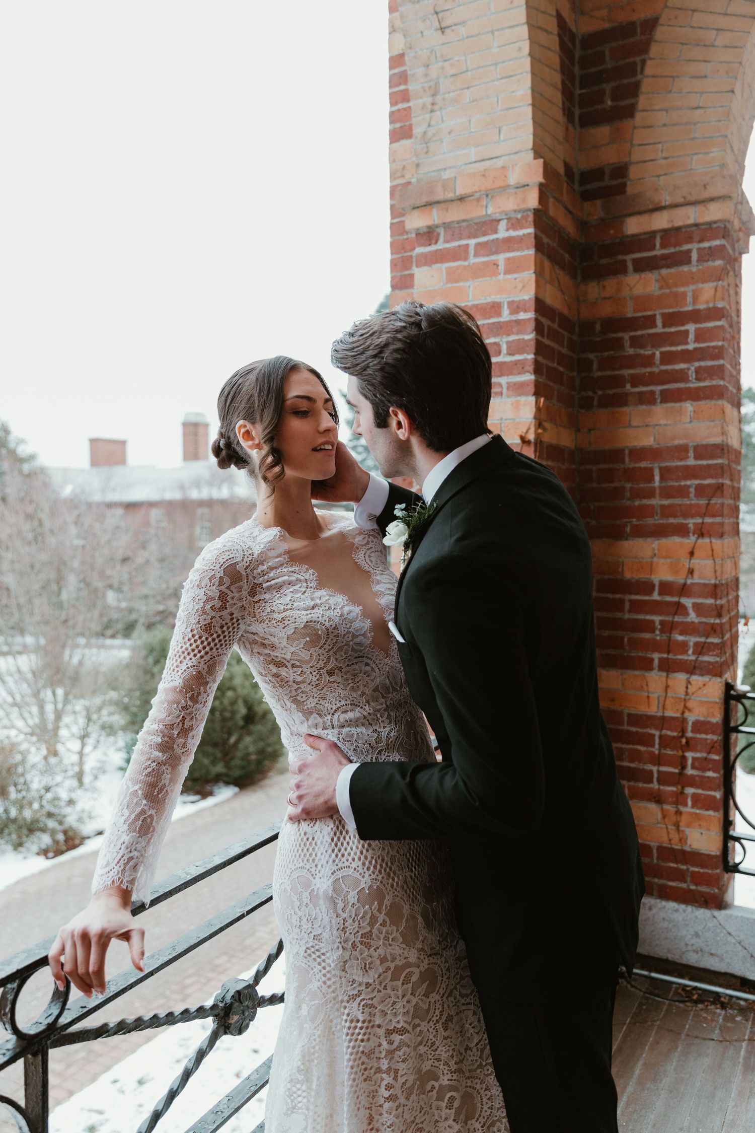 Romantic winter wedding portrait on a brick balcony.