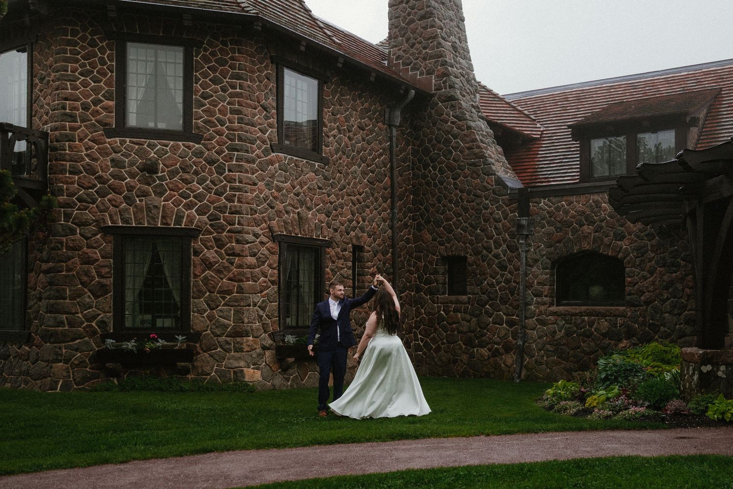 Stone buildings with red roofs create a rustic backdrop for an outdoor wedding setting.