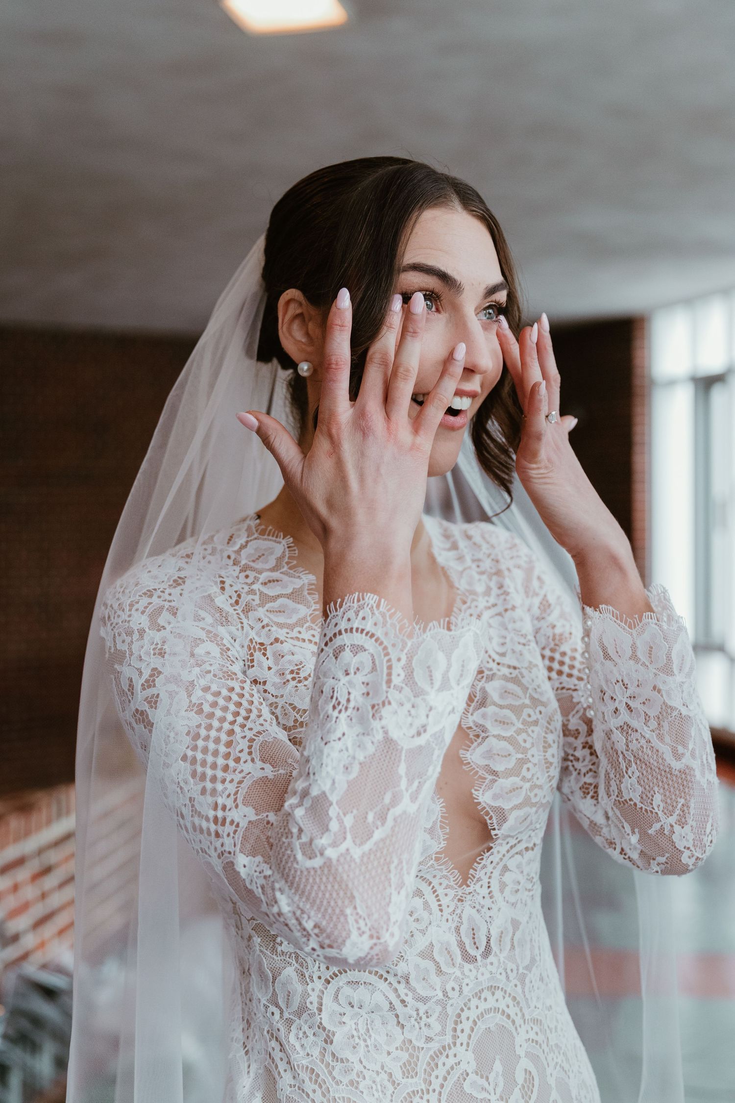 A close-up of delicate lace details on a wedding dress with veil.