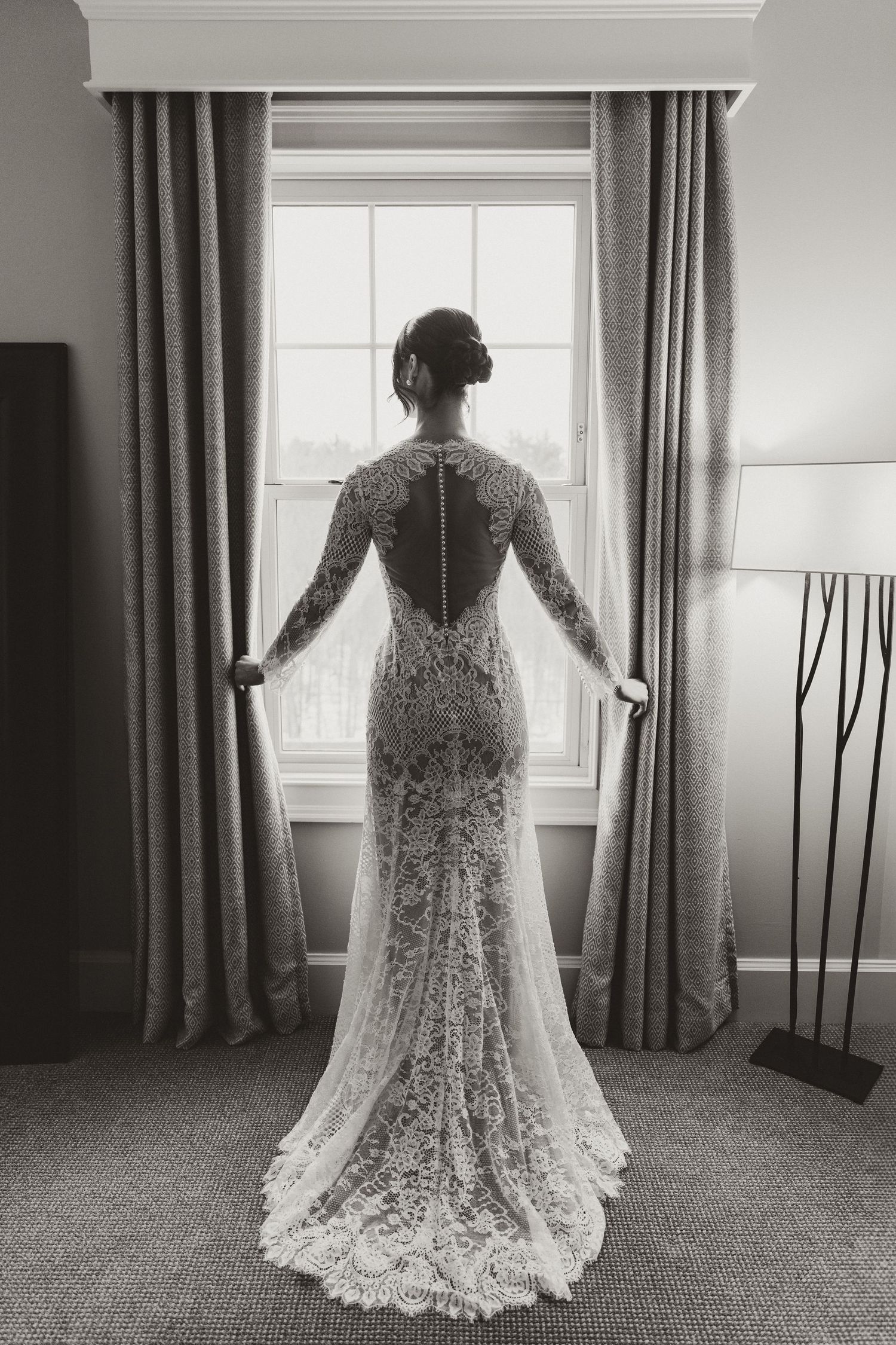 Back view of intricate lace wedding dress with sheer details and long sleeves.