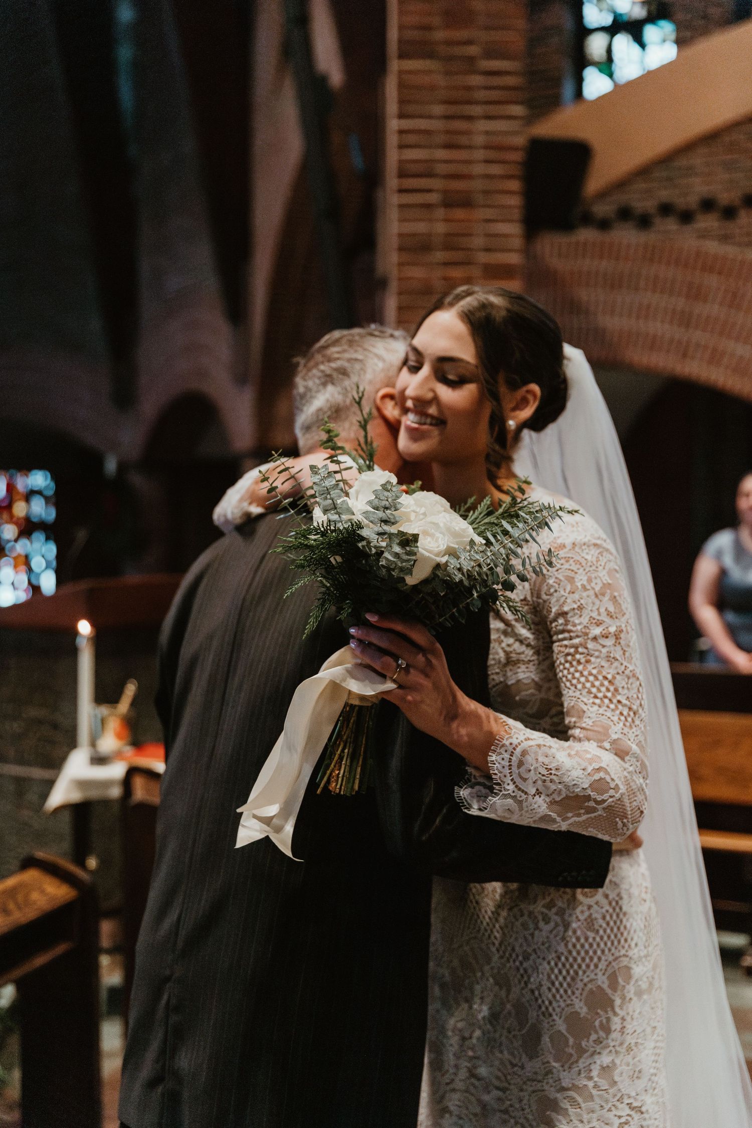 Joyful wedding moment with white bouquet in a traditional church setting.