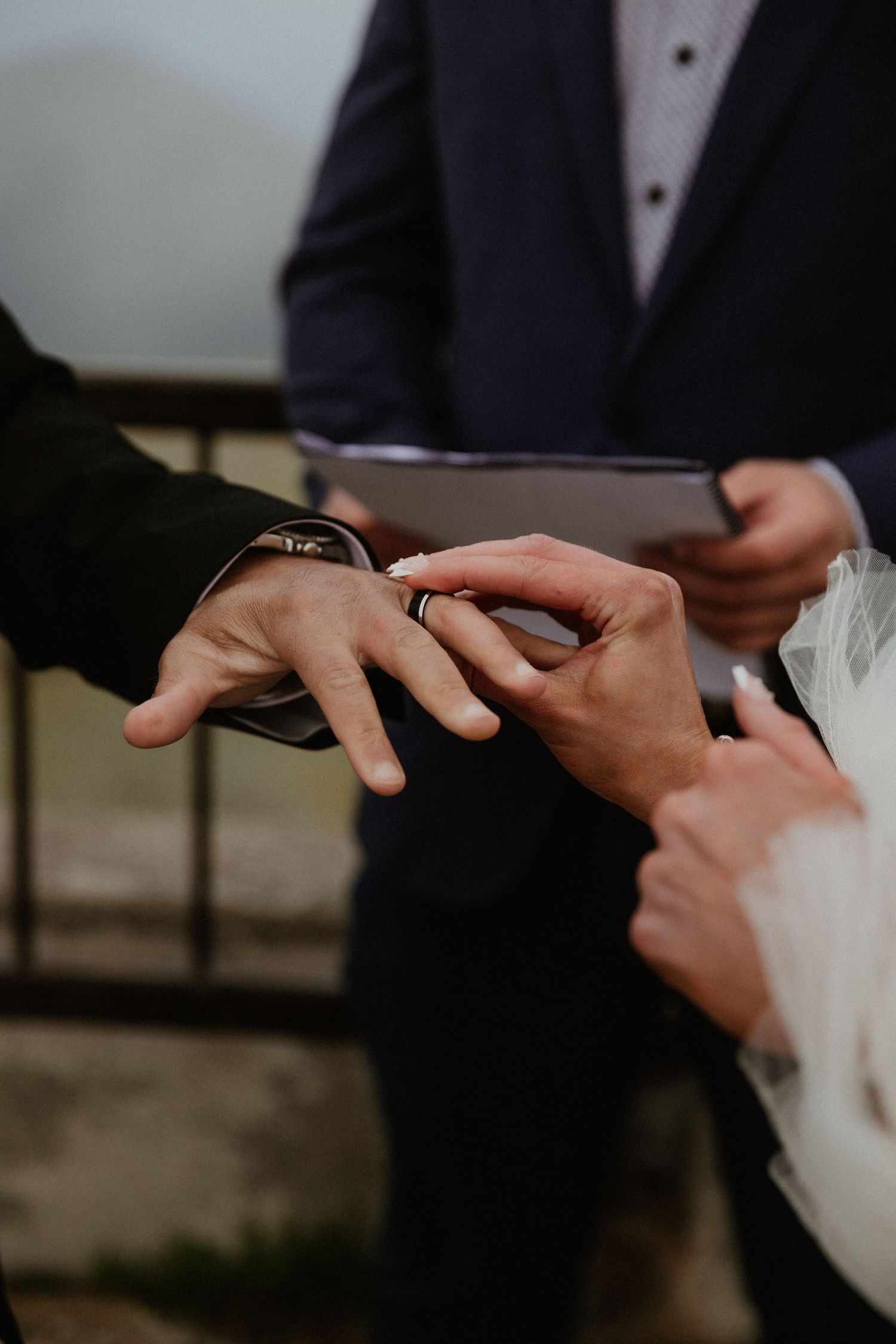 Close-up of hands exchanging rings during wedding ceremony.