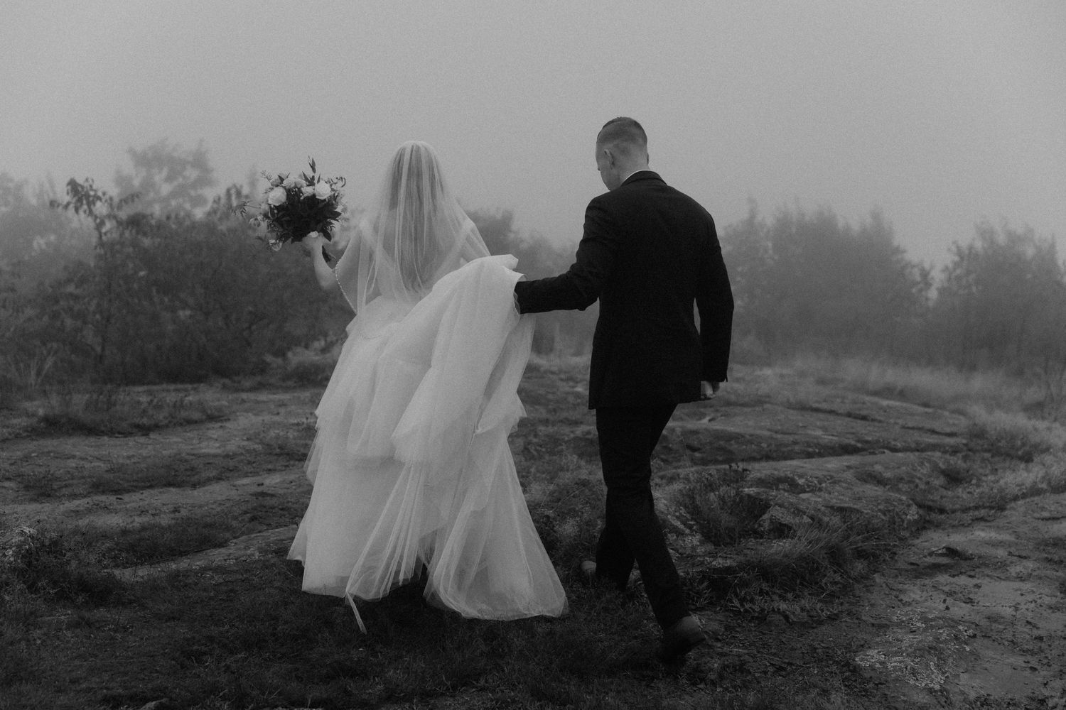 groom holding brides dress