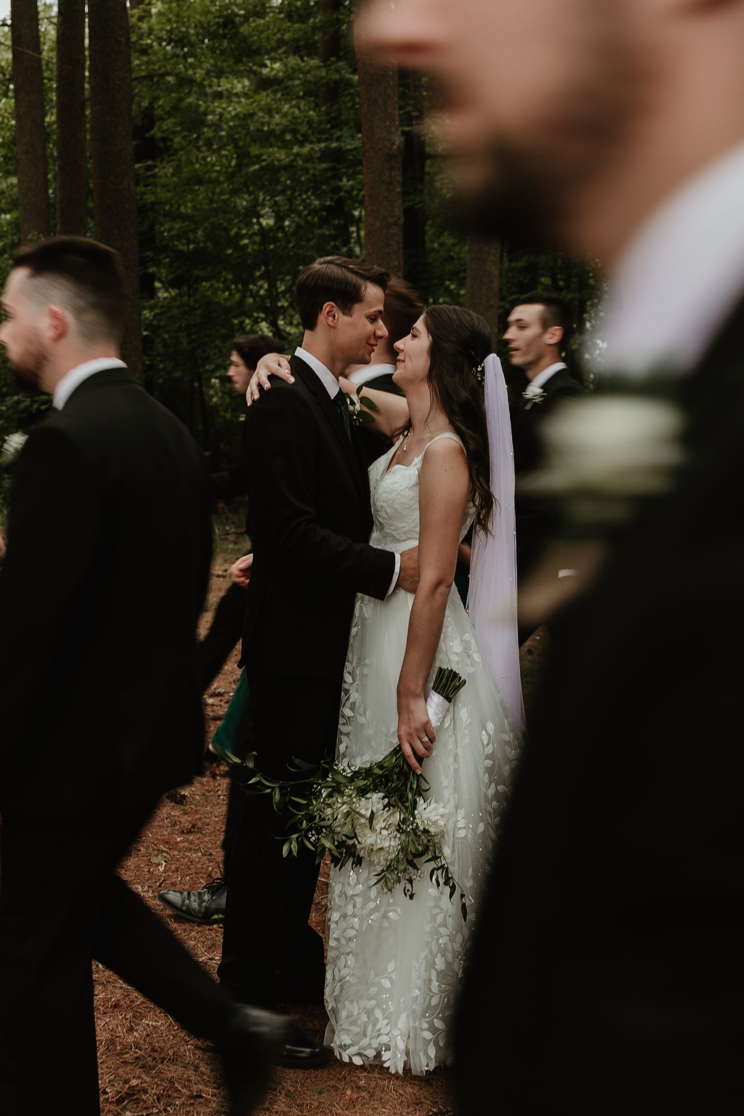A series of intimate wedding ceremony moments captured in a wooded forest setting with couples and guests in formal attire.
