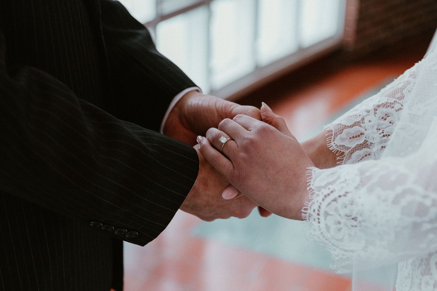 Close-up shot of hands exchanging rings during a wedding ceremony.