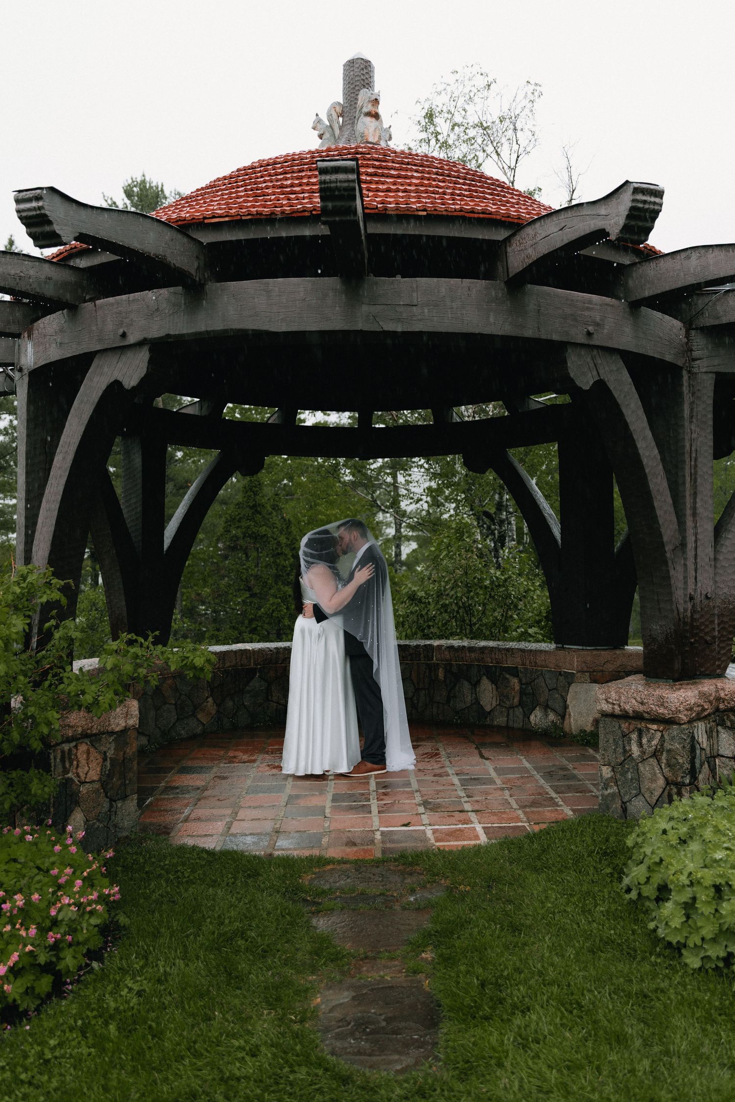 A rustic stone patio with dark wooden beams overhead creates an intimate outdoor space.