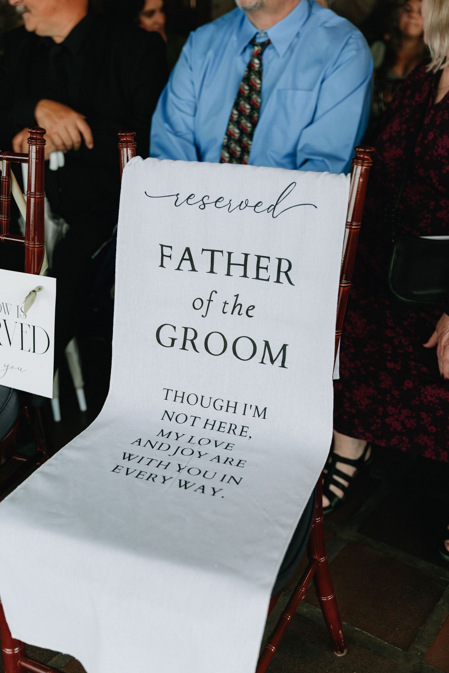 Reserved seating signs for wedding party members displayed on white paper at ceremony.