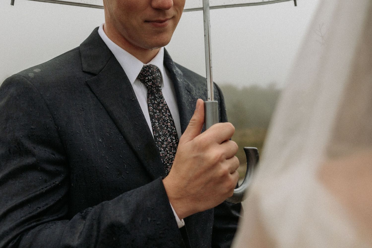 groom holding umbrella