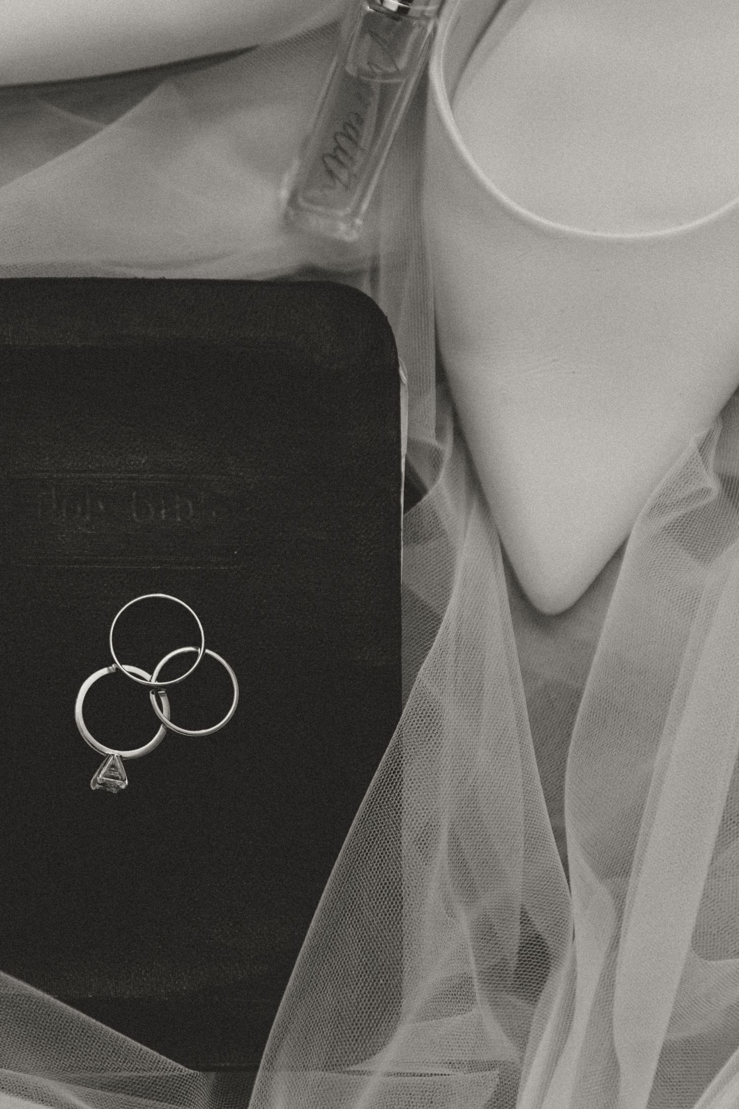 Wedding rings and jewelry artistically arranged in black and white.