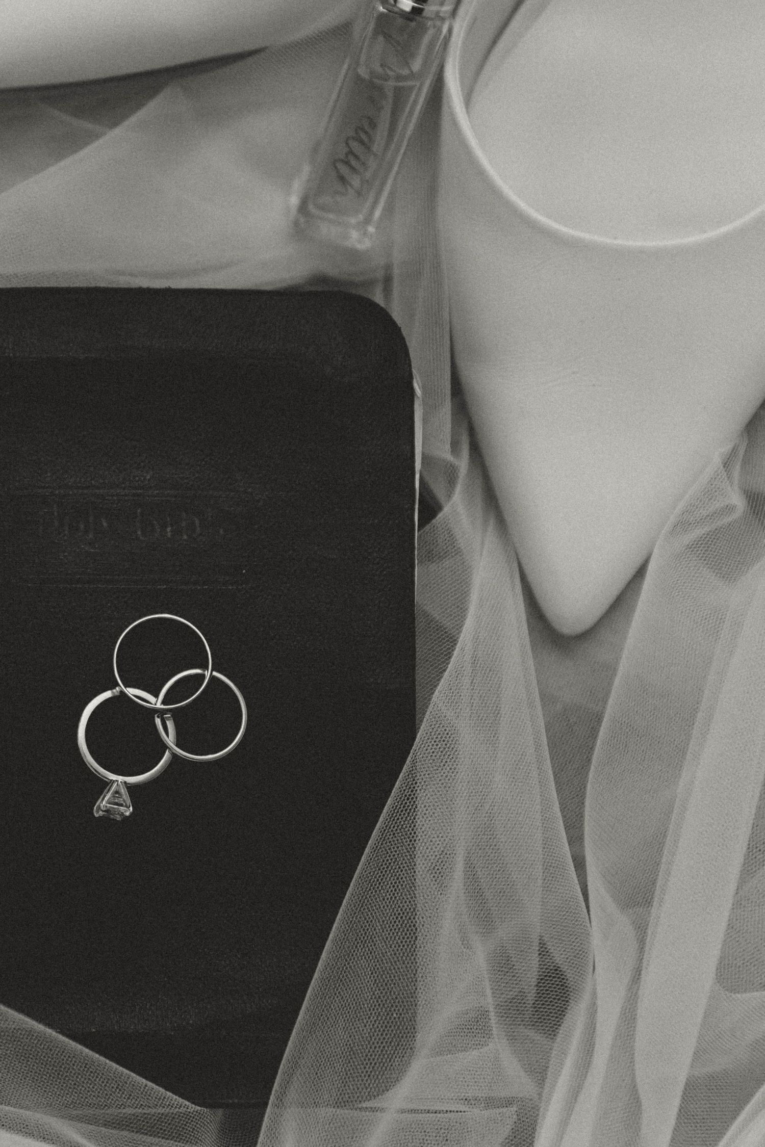 Wedding rings and bridal accessories arranged in black and white monochromatic style.
