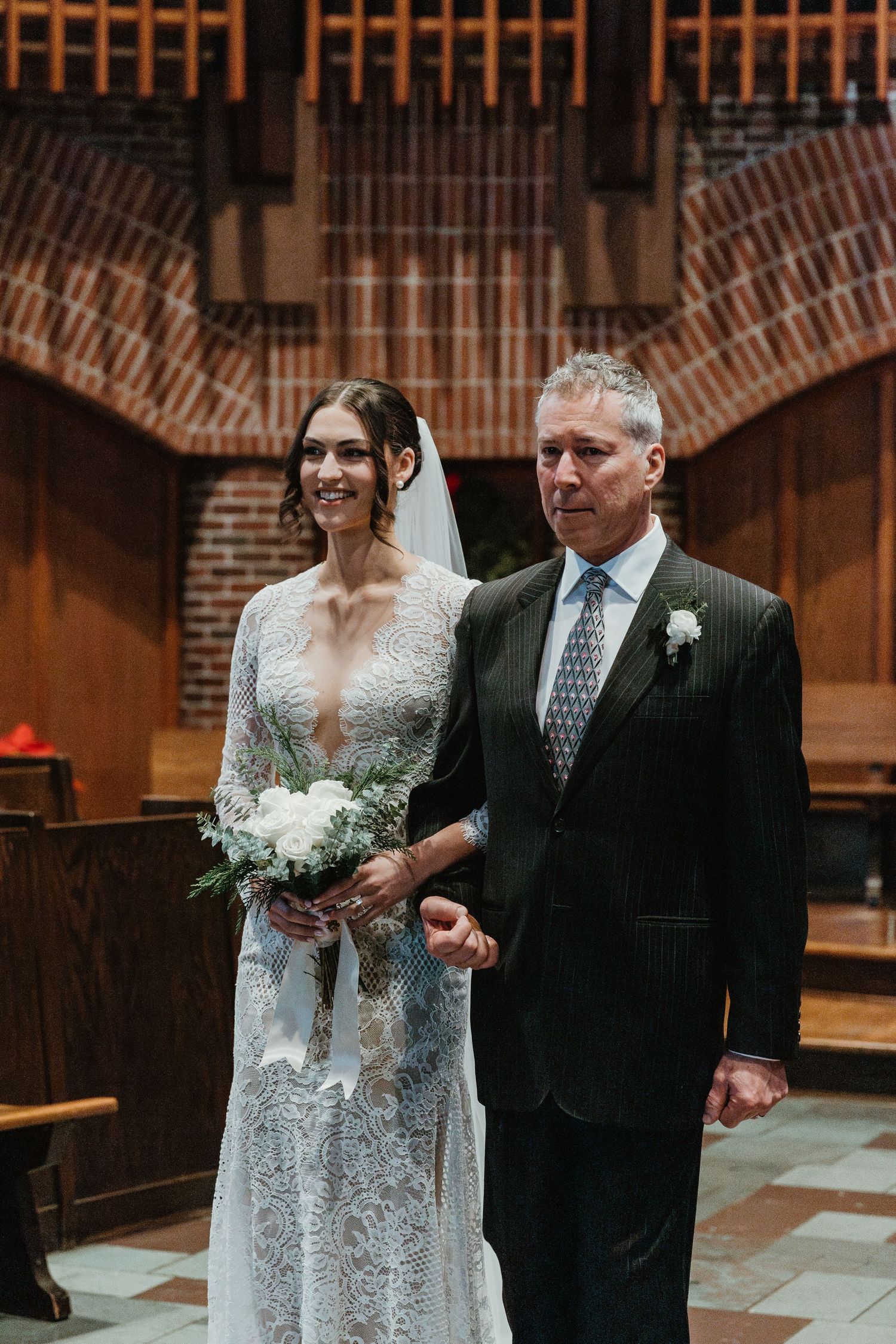 Wedding ceremony in a beautiful brick church with vaulted ceilings and wooden details.