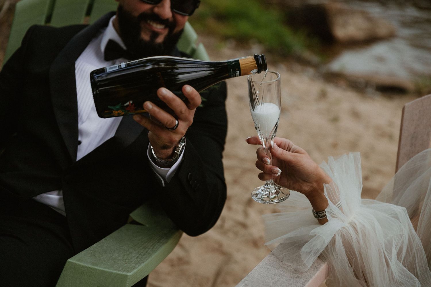 Wedding guests toasting with drinks in a casual outdoor setting.