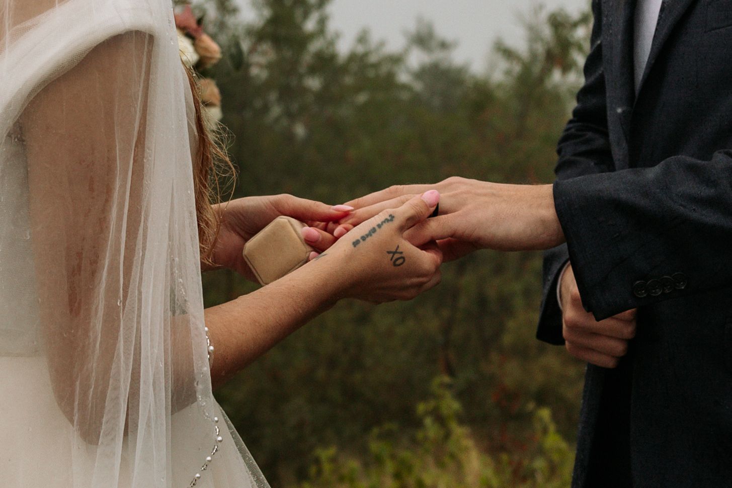 bride putting ring on groom