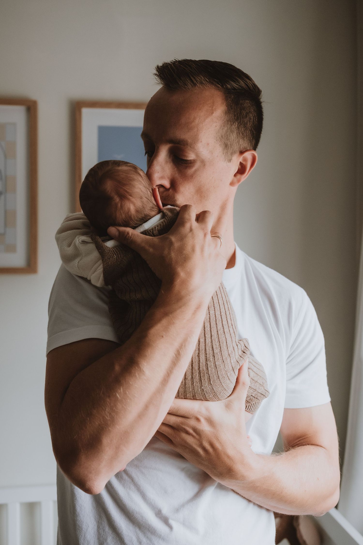 Liefdevolle papa die zijn pasgeboren zoon zachtjes een kusje geeft