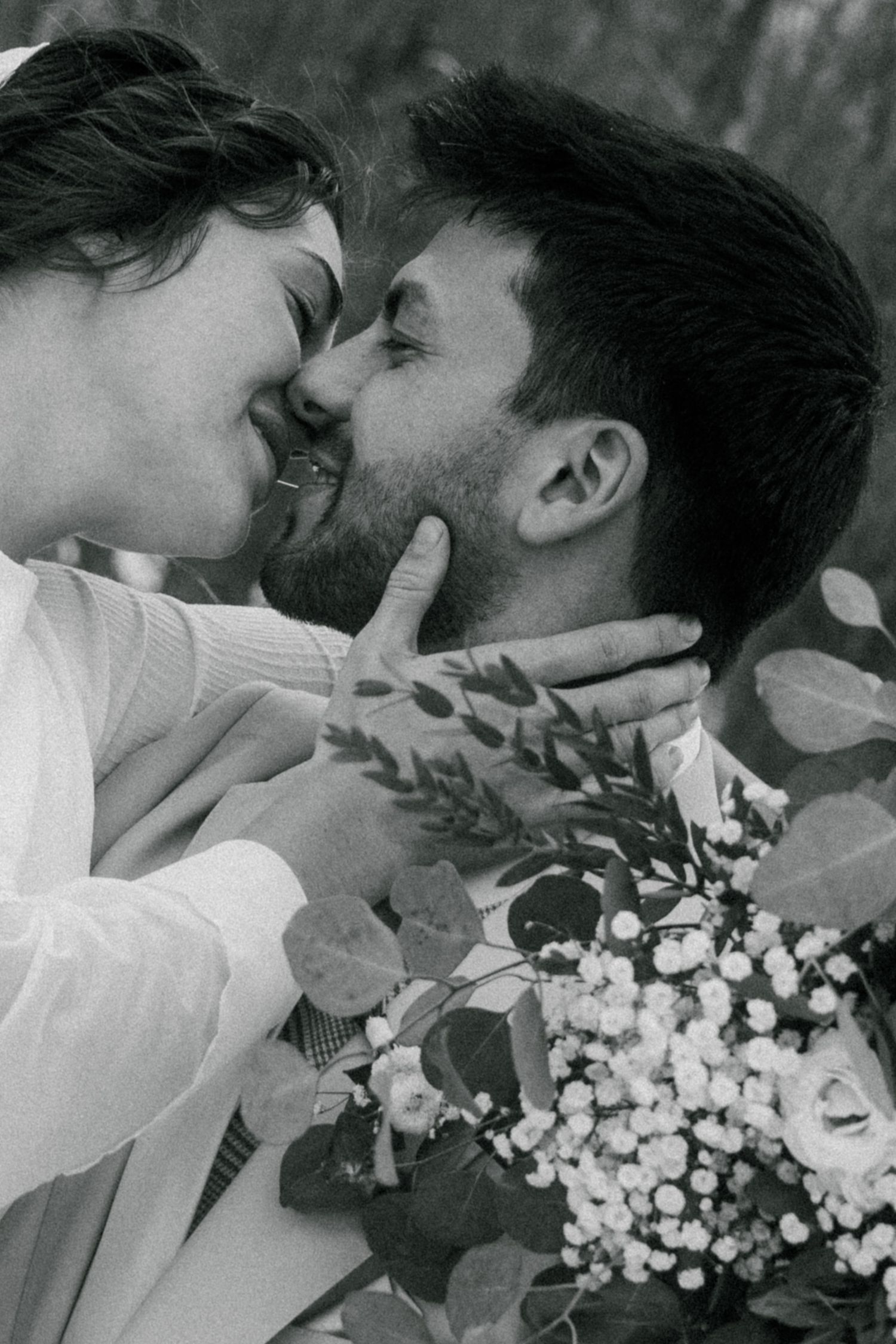 Intimate black and white portrait of newlyweds sharing a tender moment.