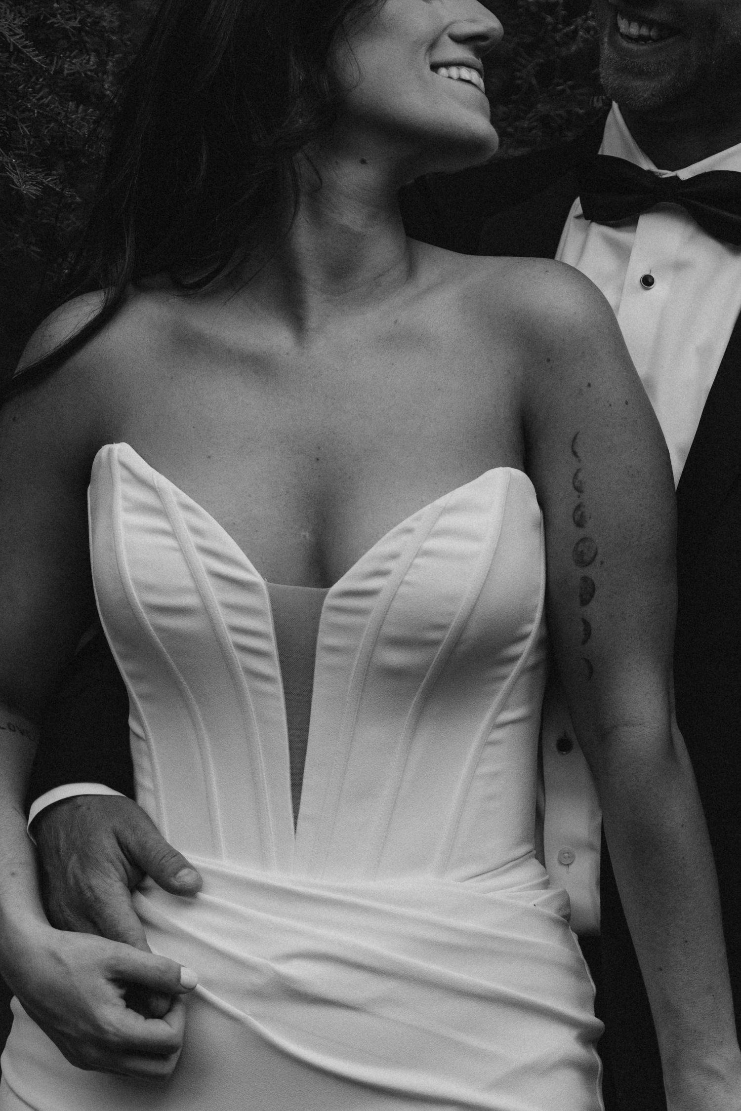 Black and white close-up of bride in strapless corset wedding gown.