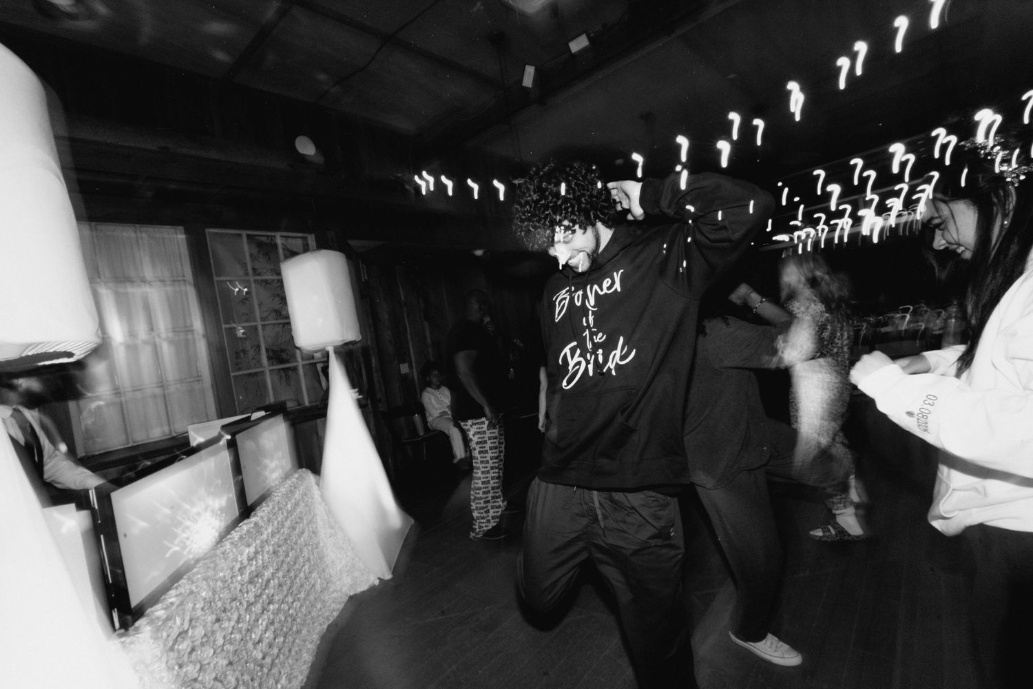 Person dancing in a Brother of the Bride jacket at a lively dark wedding reception party.