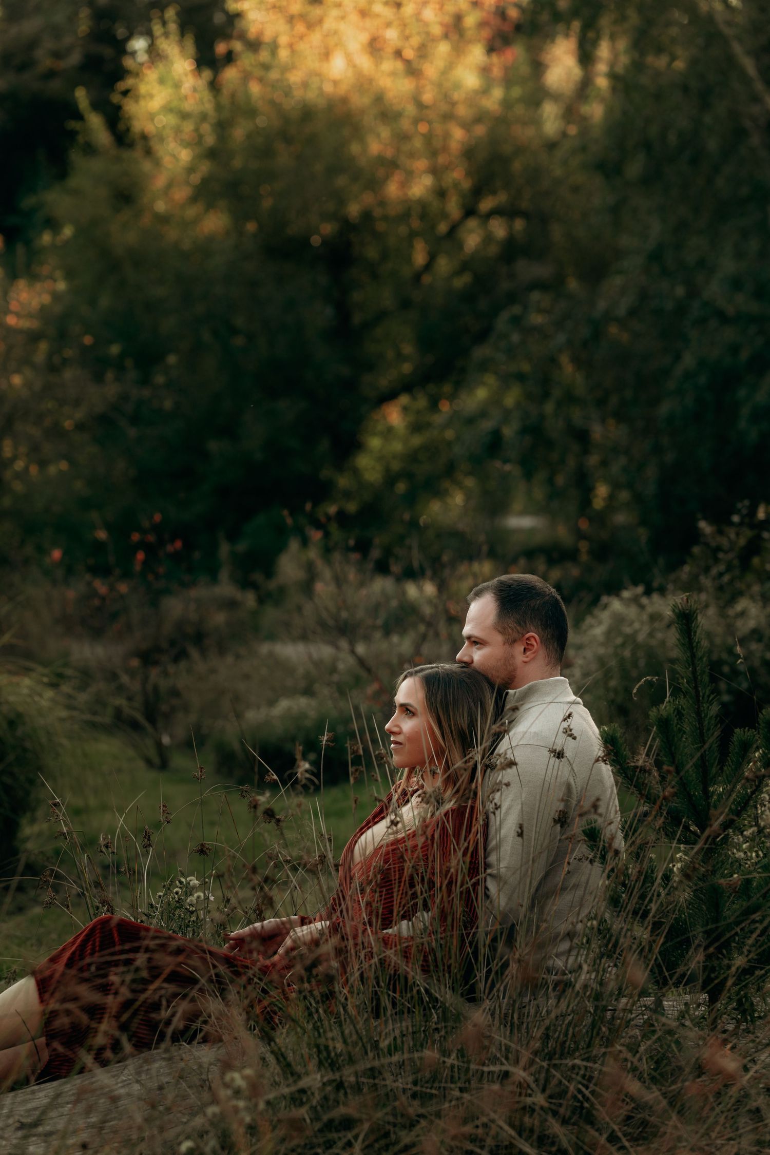 Romantic couple sitting together in a lush autumn garden landscape.