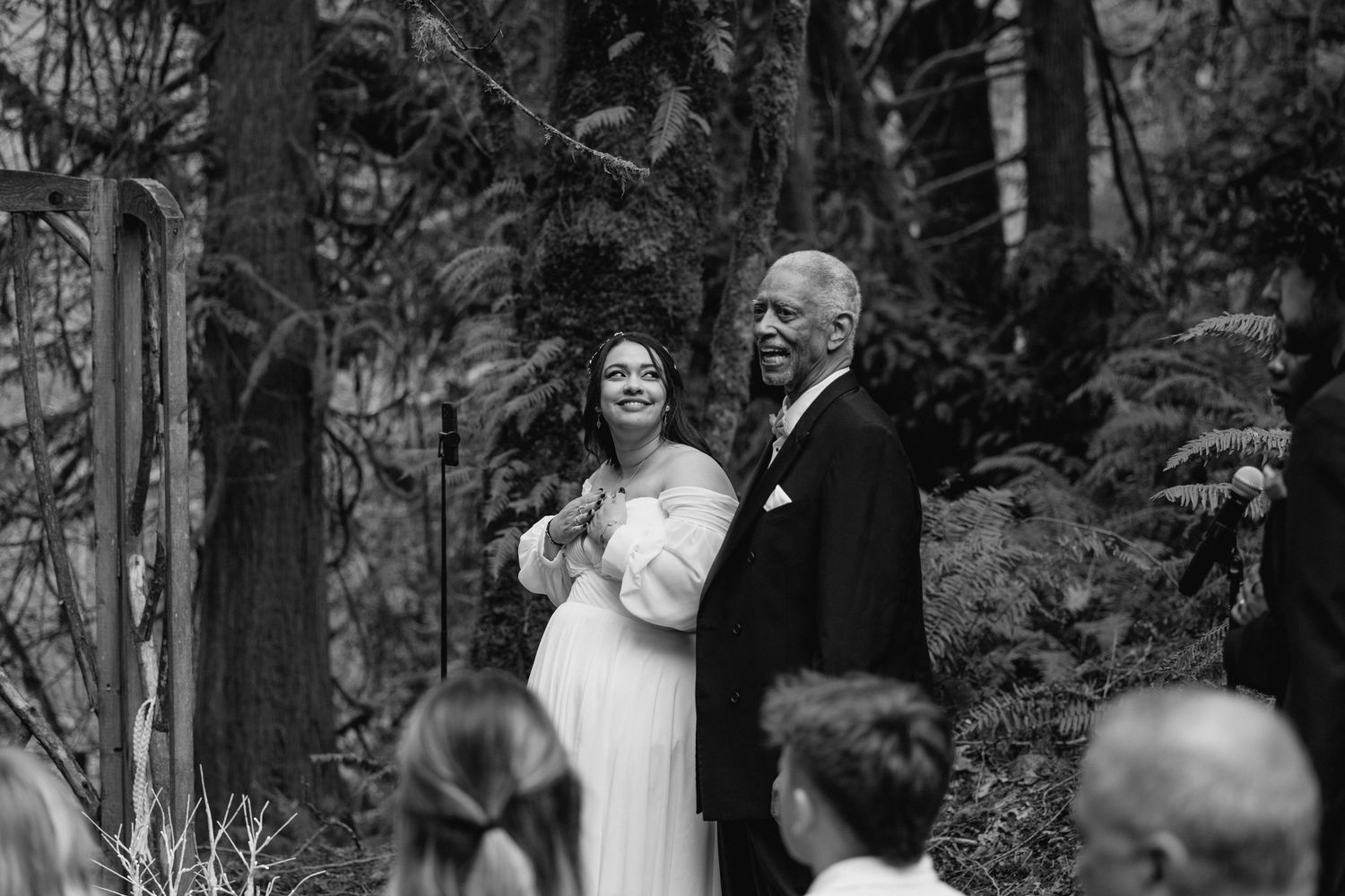 Bride and father share a tender moment walking down the aisle at outdoor wedding ceremony.