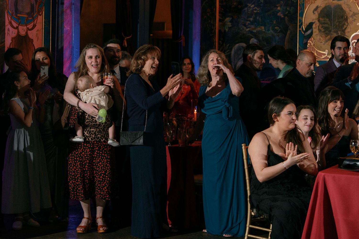 Wedding guests watching ceremony in ornate decorated venue.