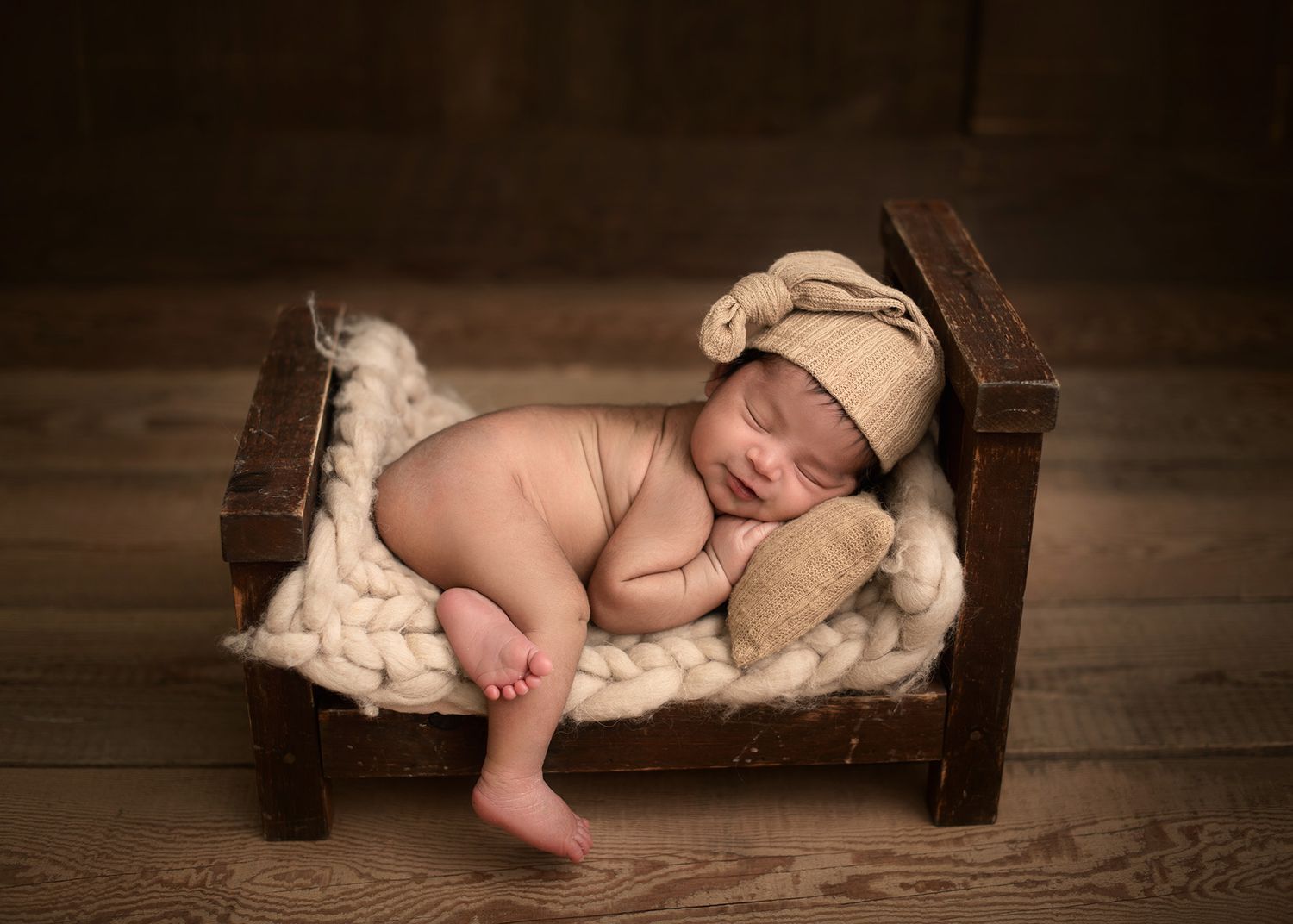 Peaceful sleeping baby in a rustic wooden bed with warm tones , soft studio portrait, Victoria BC newborn photography