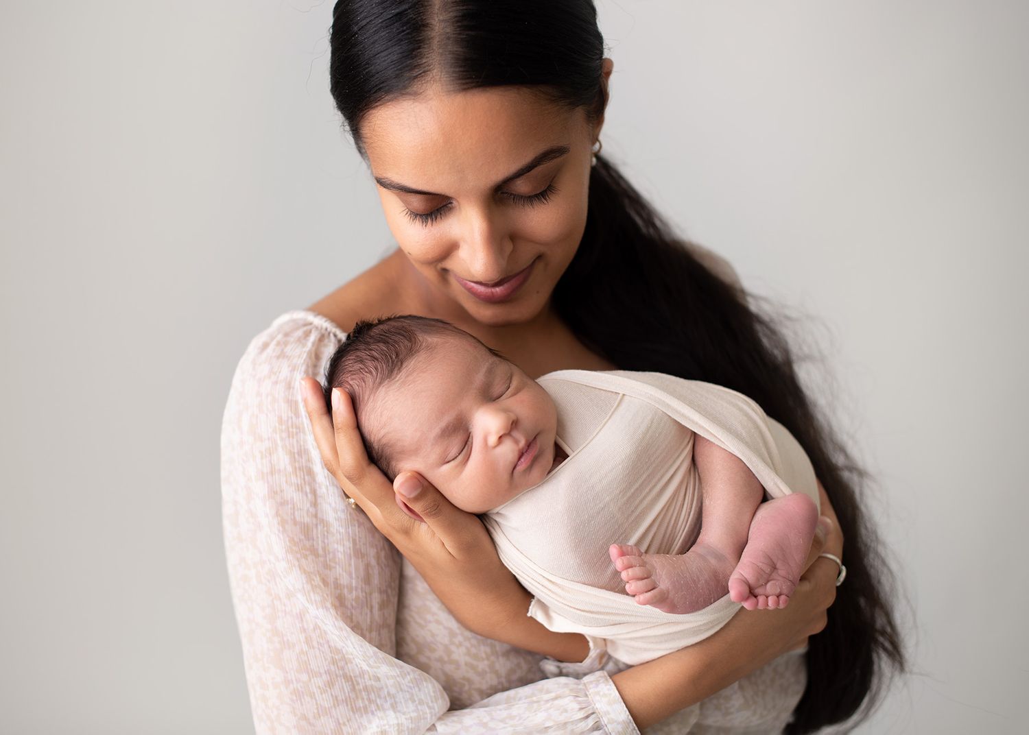 mother holding swaddled newborn baby close in arms, studio portrait, Victoria BC newborn photography