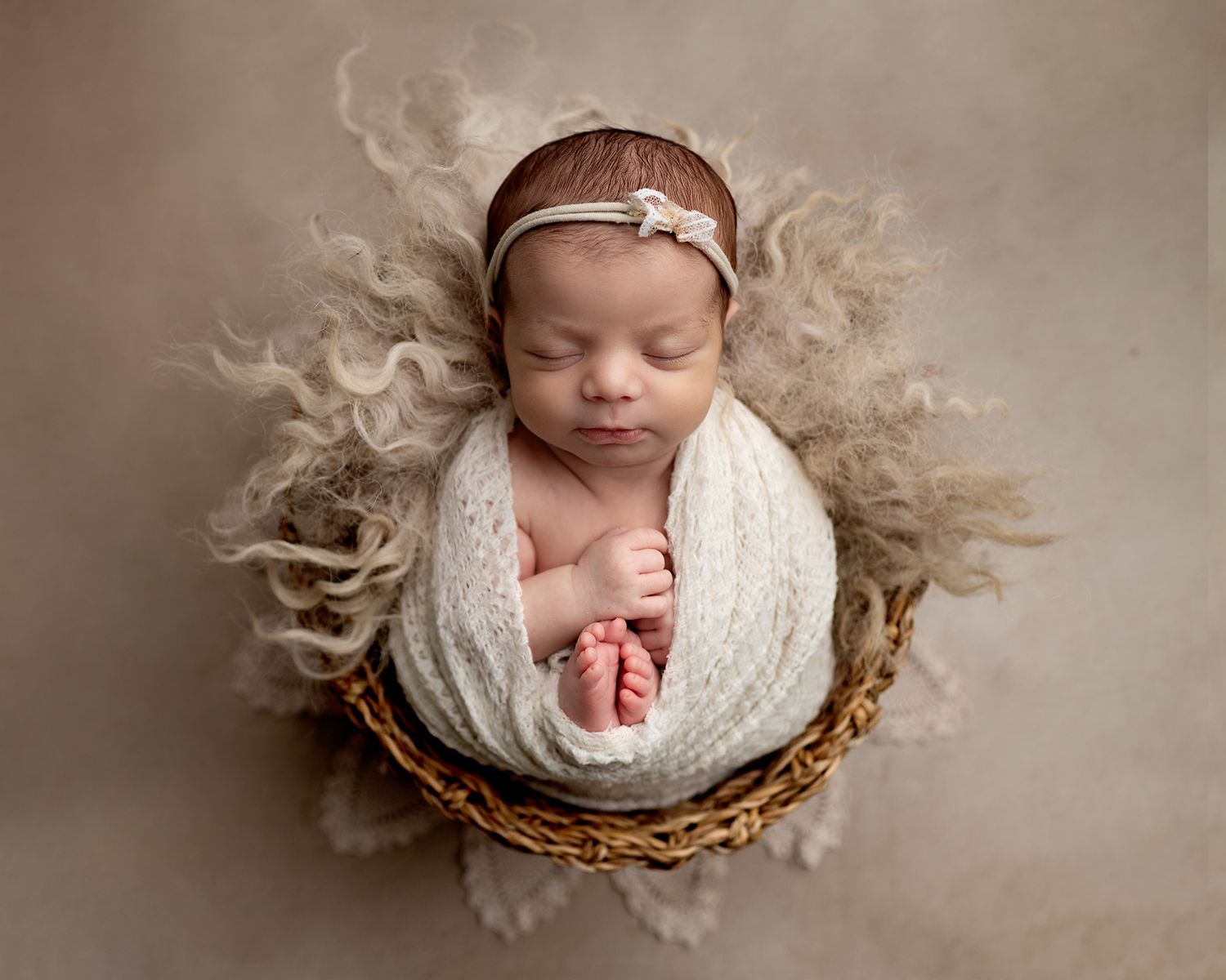 Newborn baby swaddled in a basket with toes peeking out, Victoria newborn photography