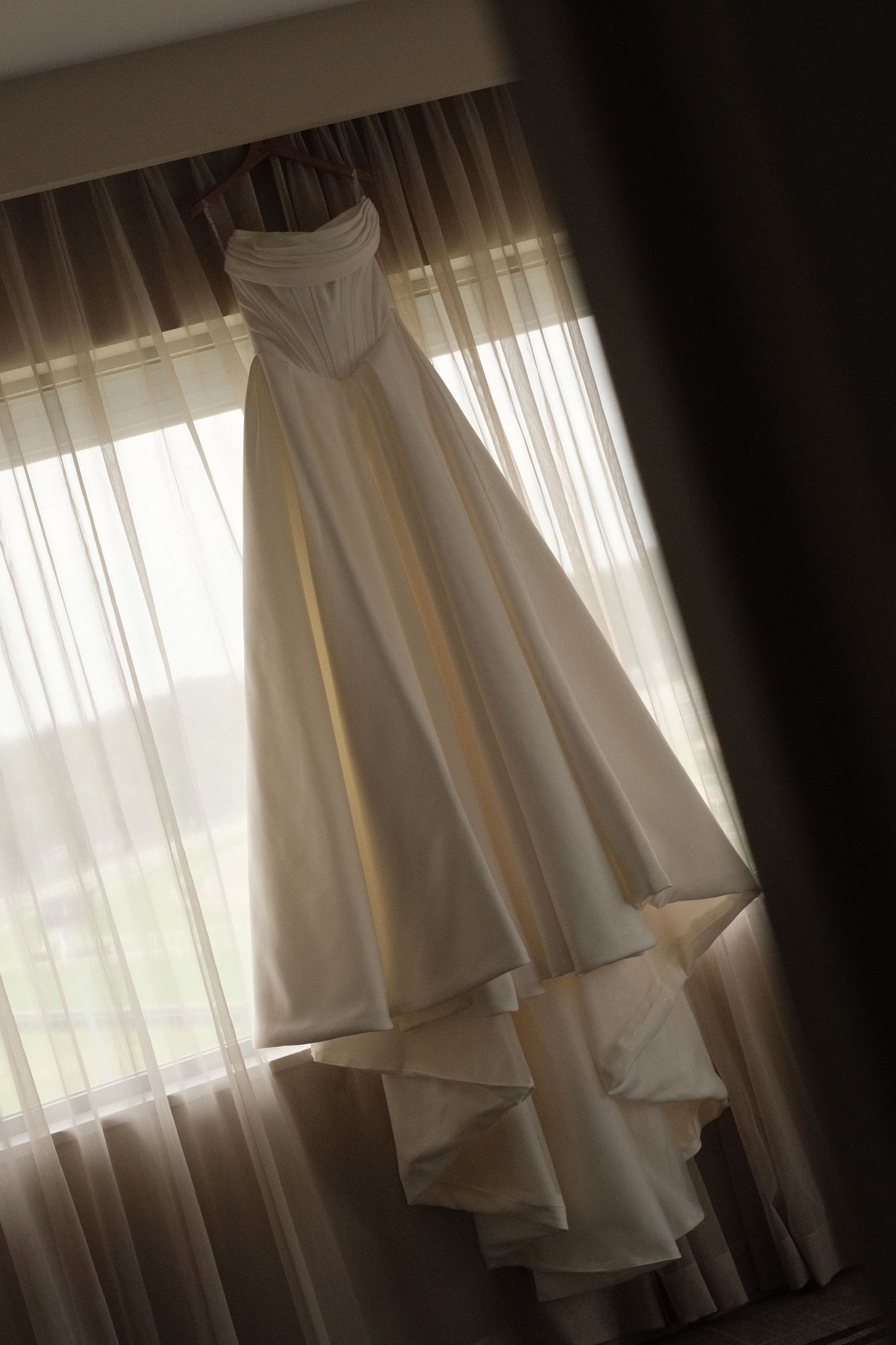 Sunlight streams through sheer white curtains creating a soft, ethereal glow in a bright interior space.