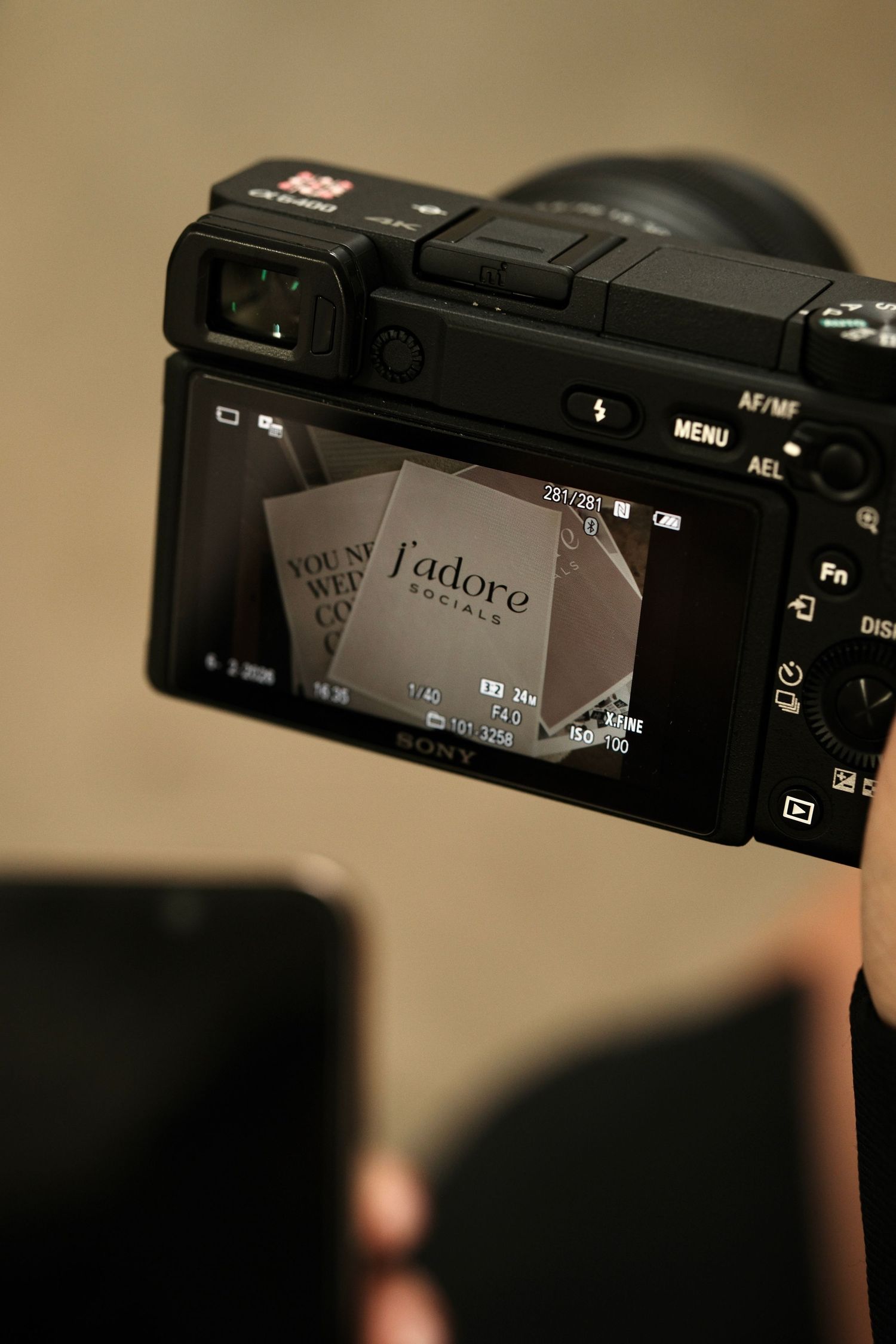 Close-up of camera display showing J'adore text in frame.