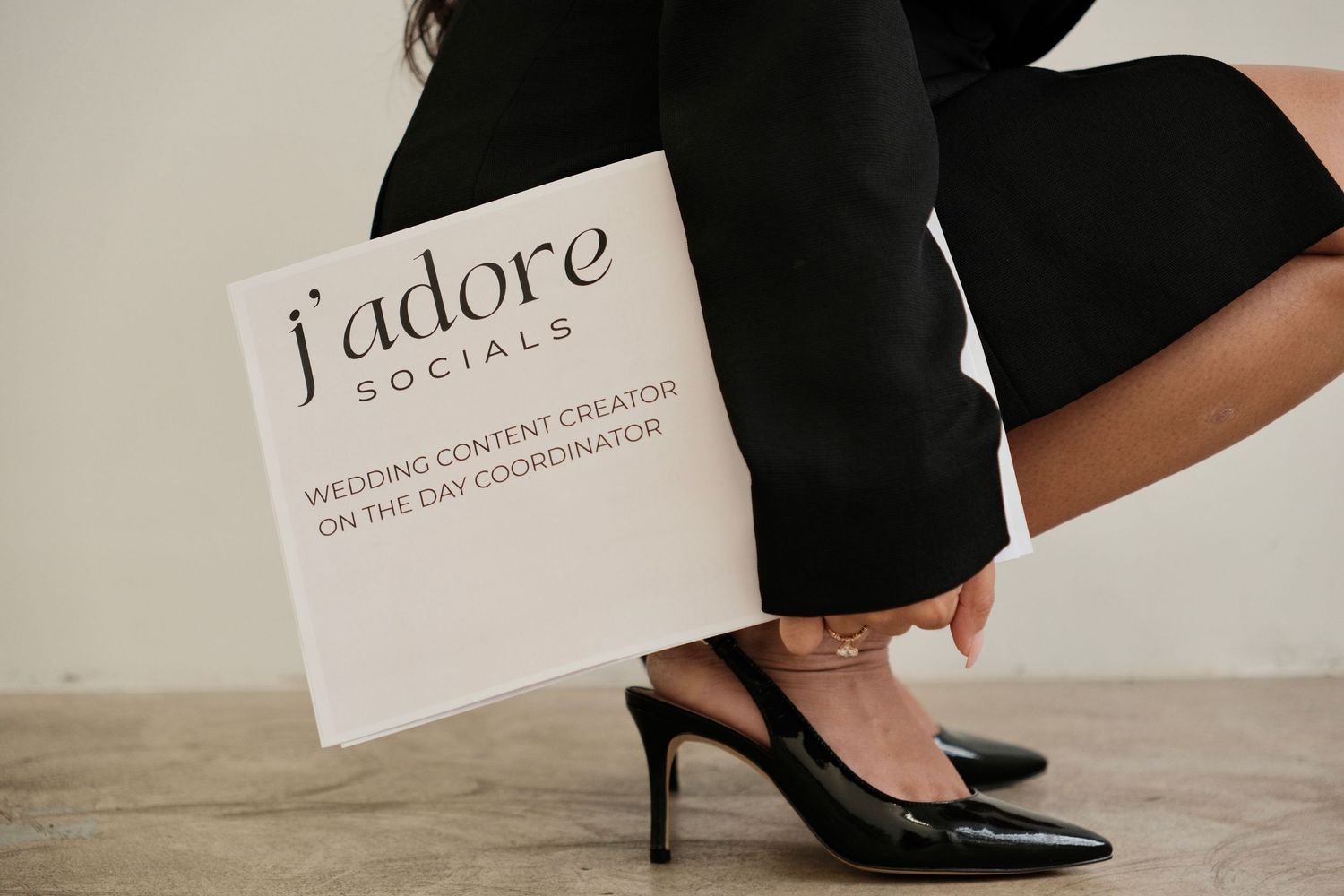 Close-up of black heels and papers with text on concrete floor.