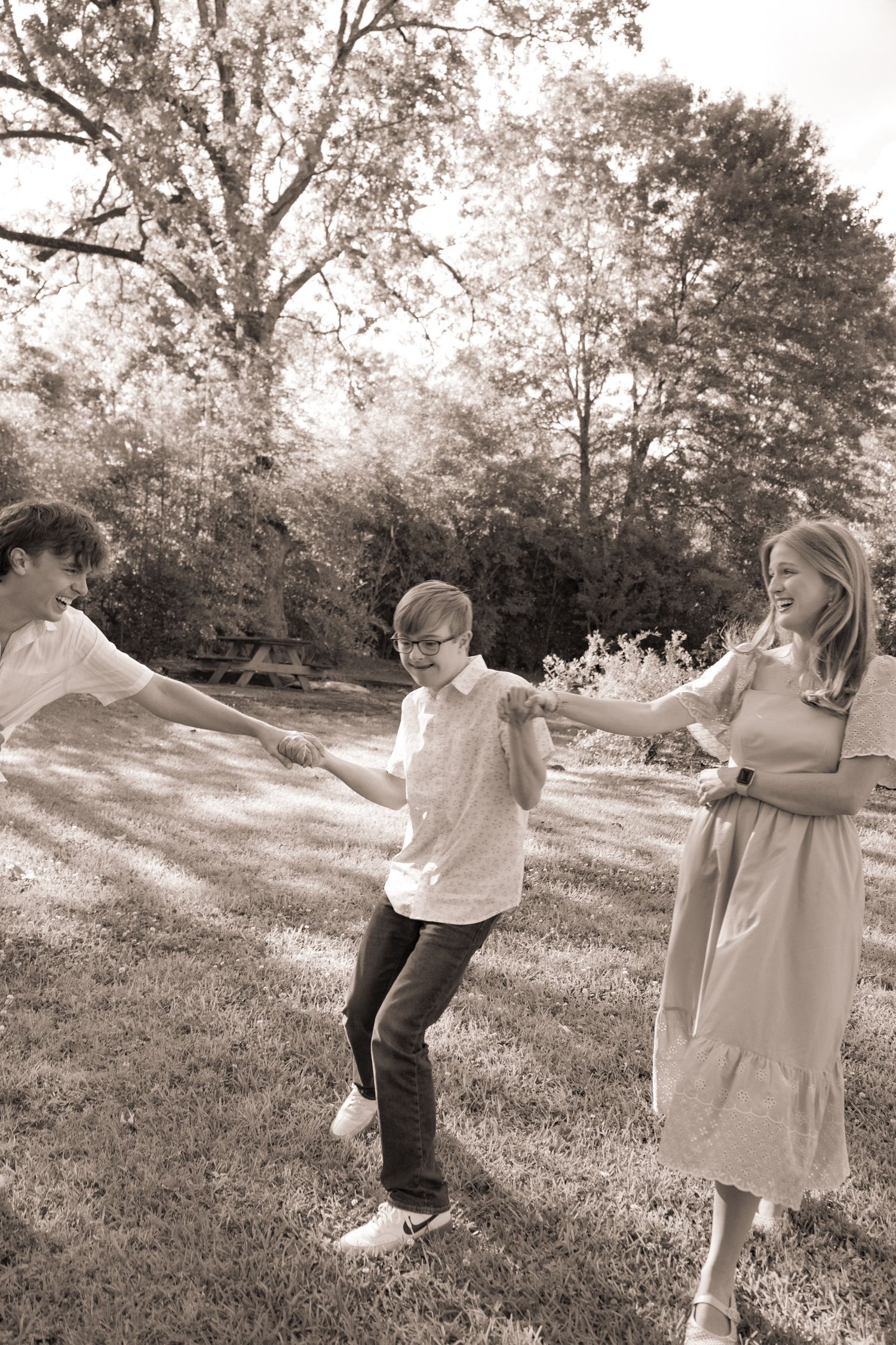Black and white series of children playing and dancing in a field.
