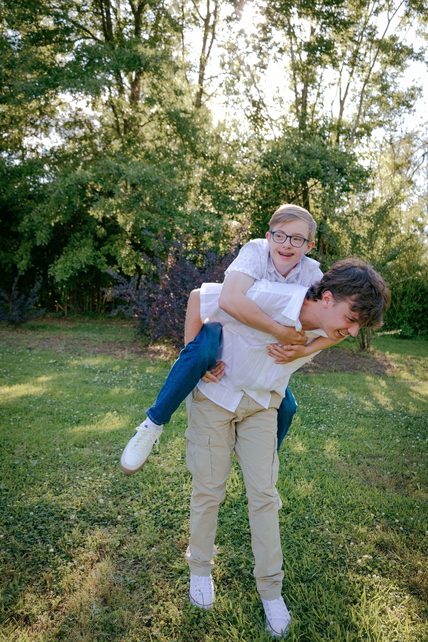 Playful piggyback rides and laughter in a sunlit grassy field.