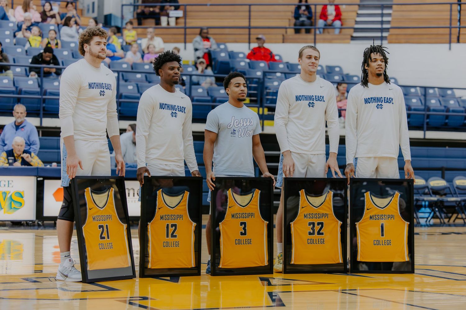 Basketball court with yellow jerseys displayed during senior recognition ceremony.