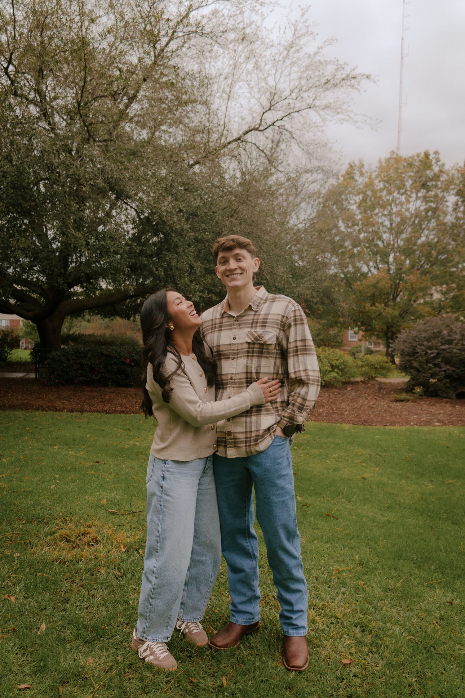 Candid moments of laughter and fun poses on an autumn lawn with trees in background.
