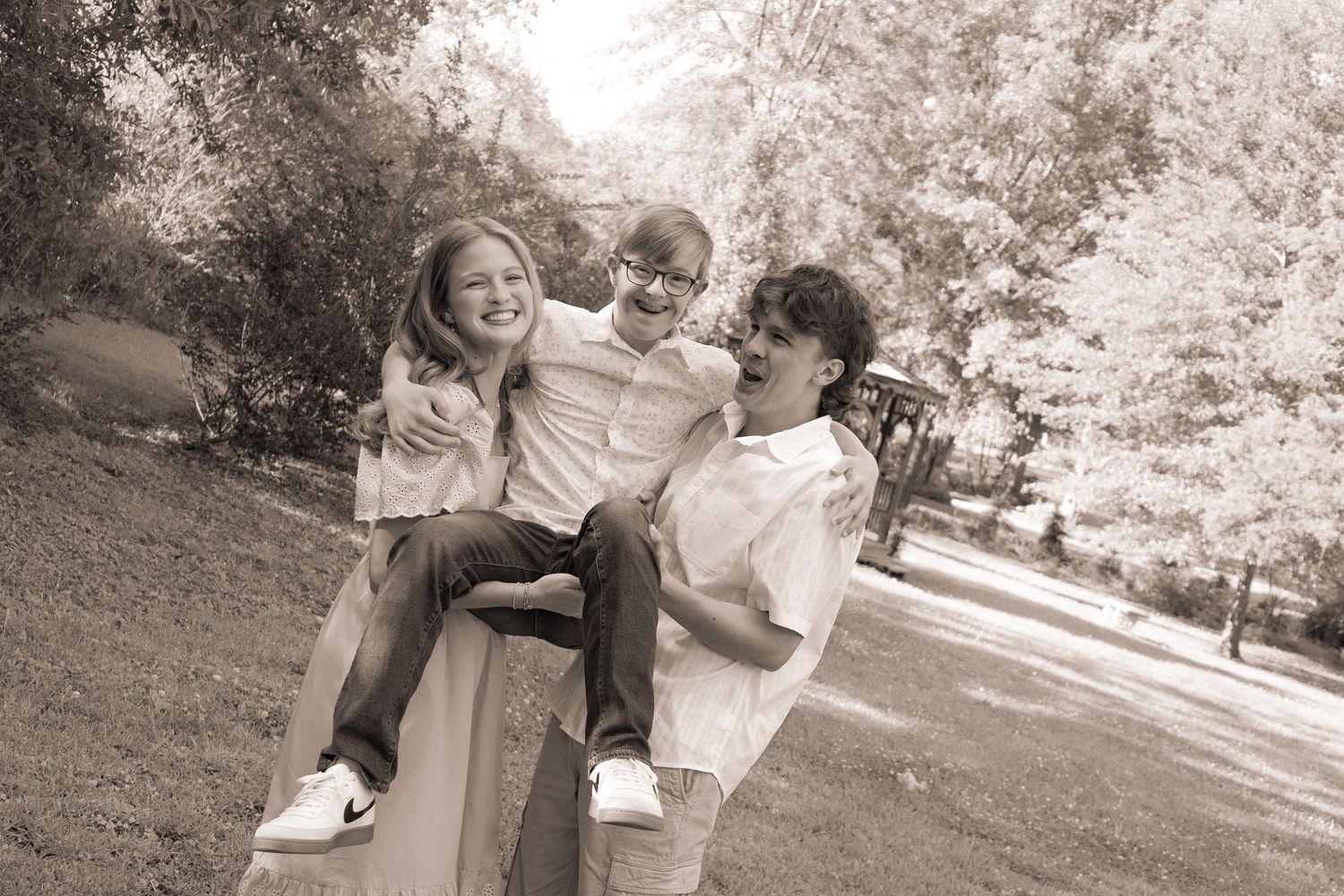 A playful black and white photo sequence of a couple laughing and embracing outdoors.