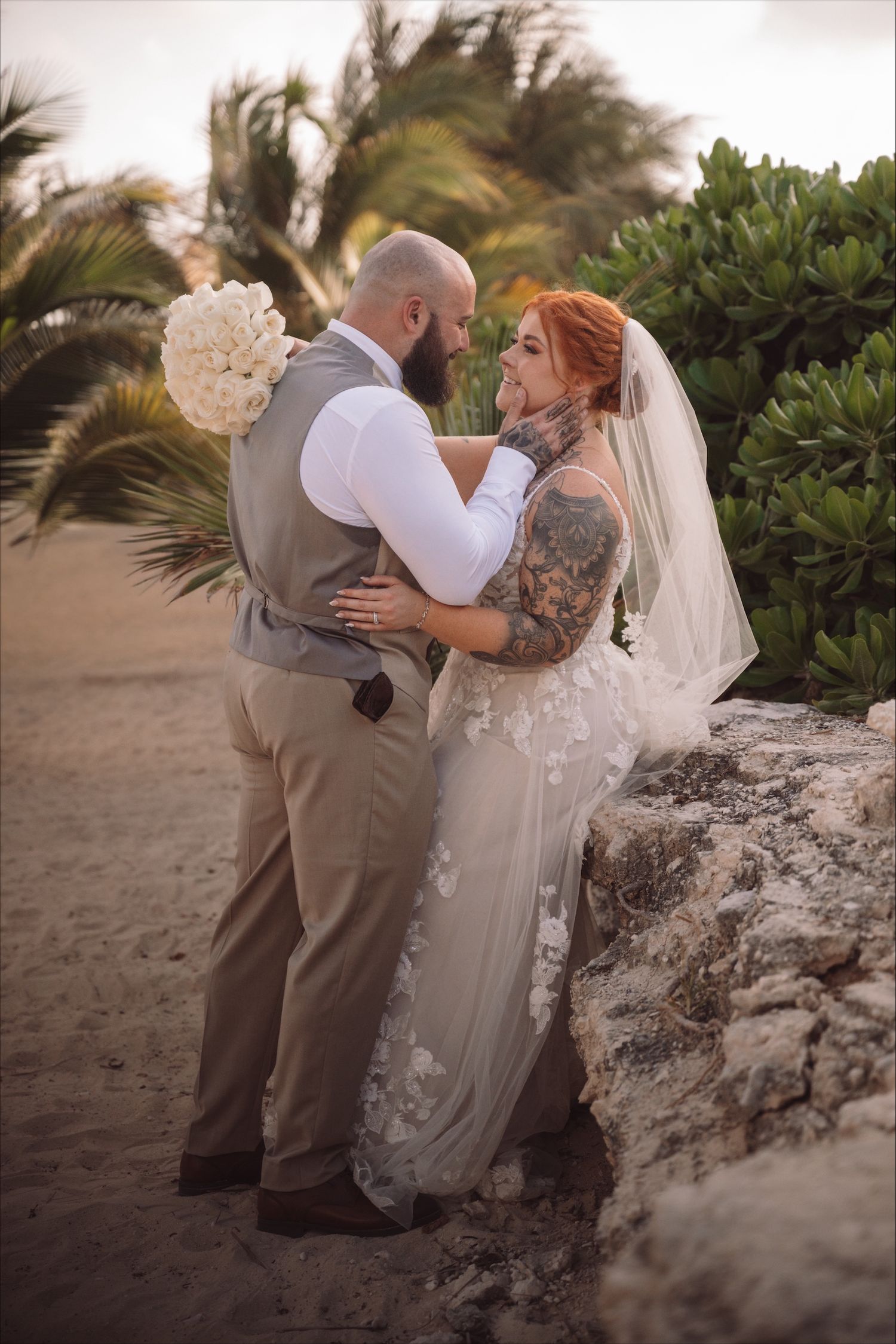 A romantic beach wedding photoshoot with palm trees and natural scenery.