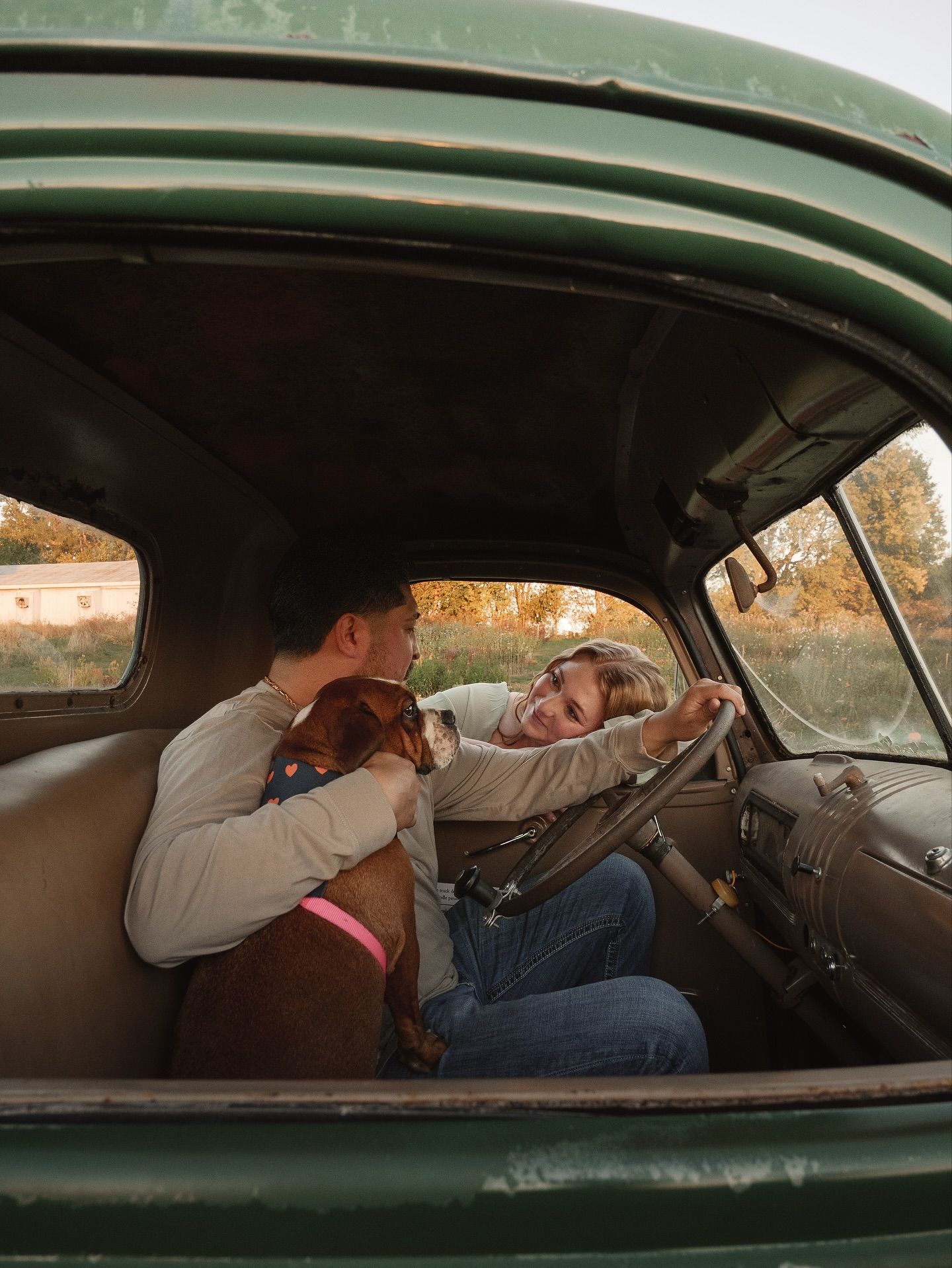 Vintage car interior scene with occupants looking through the windshield.