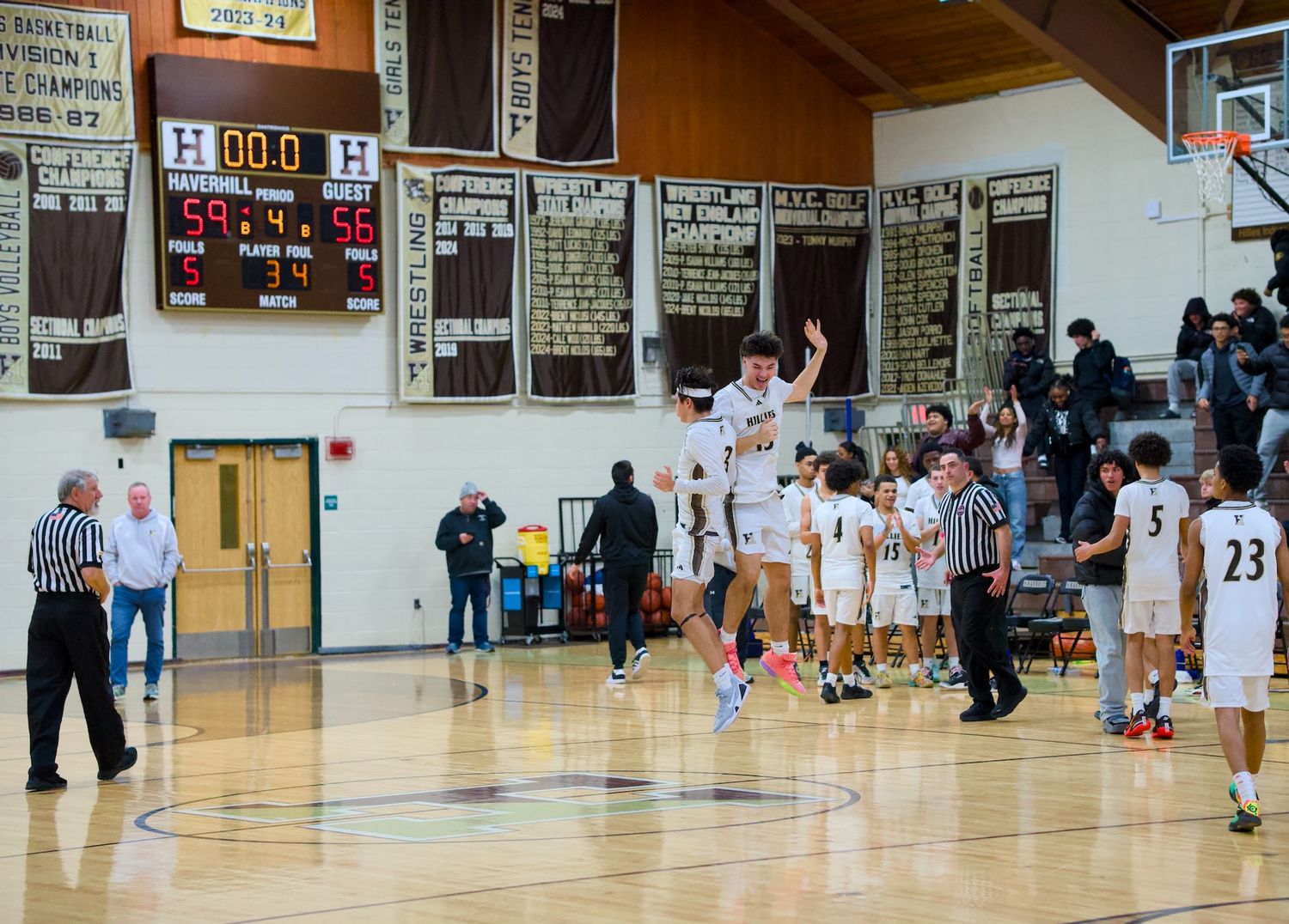 Haverhill basketball players jump to celebrate a victory.