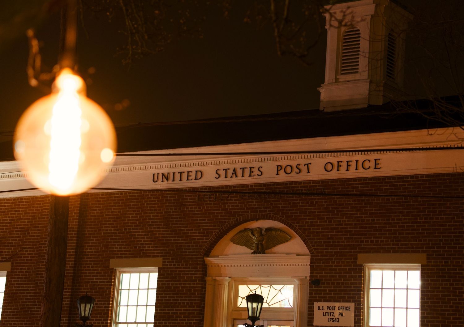 Post office building and a hanging lightbulb in Lititz, PA.