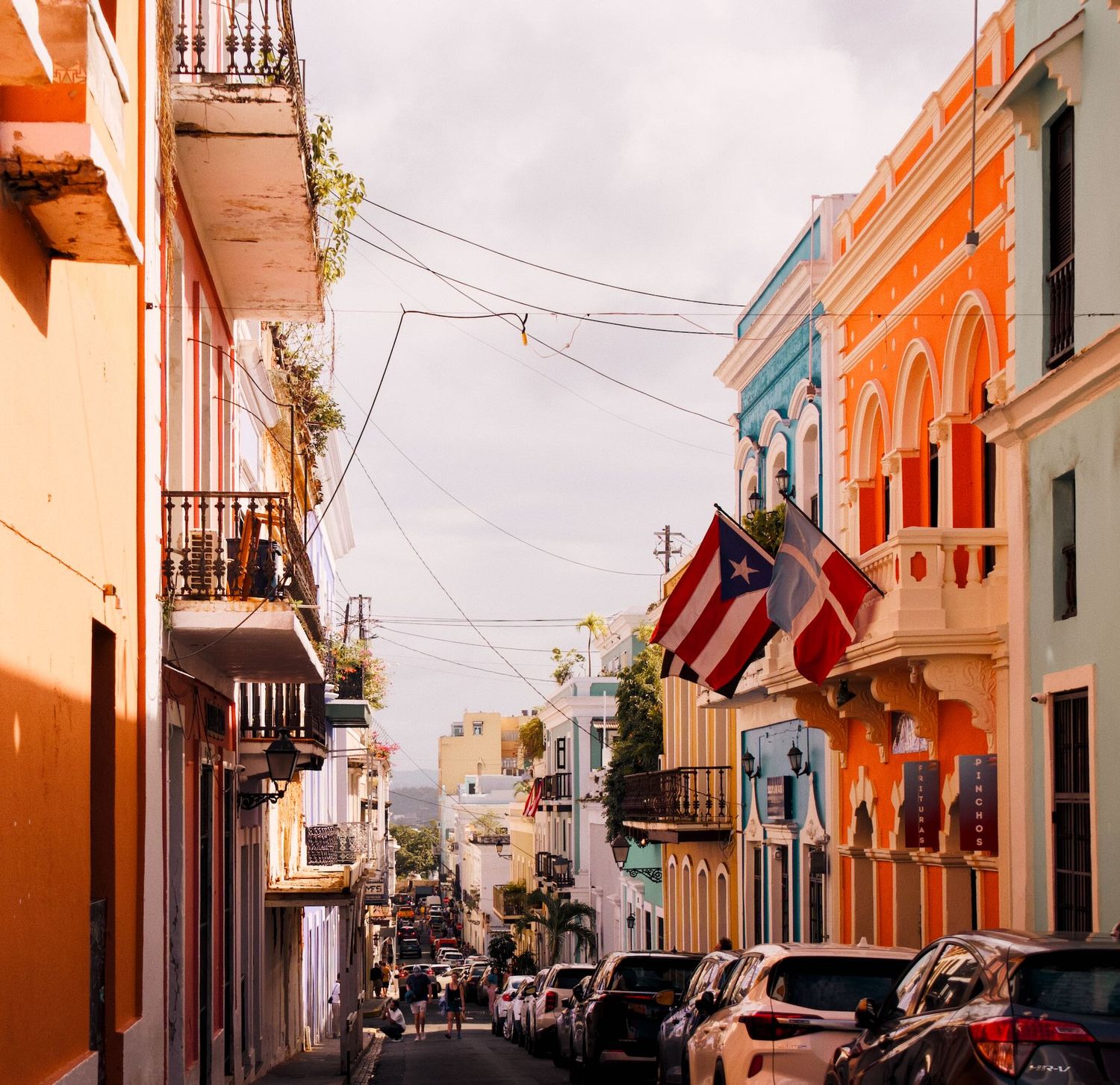 Colorful street with orange and blue buildings in Old San Juan.