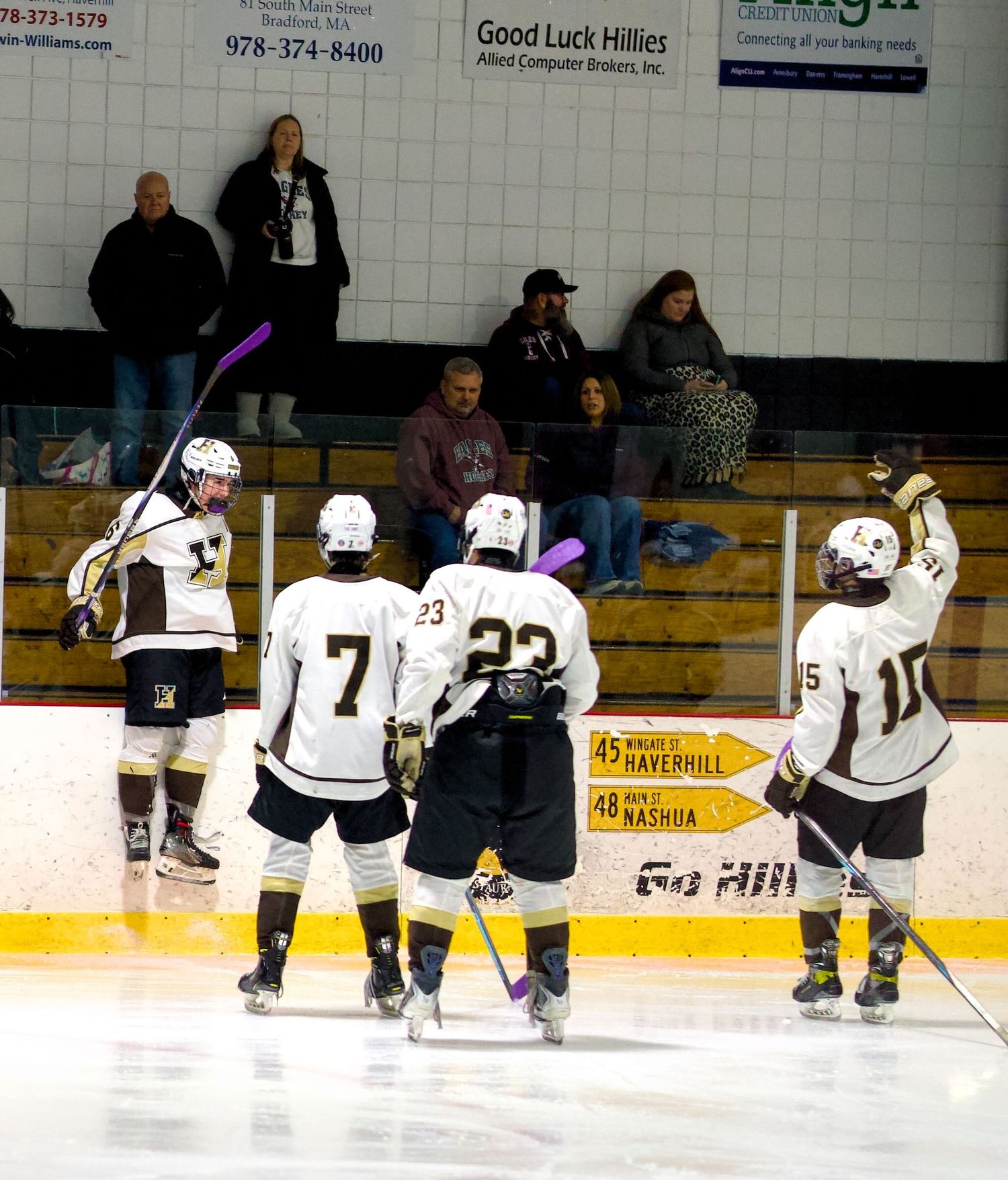 Haverhill hockey player leaps into the boards celebrating a goal.