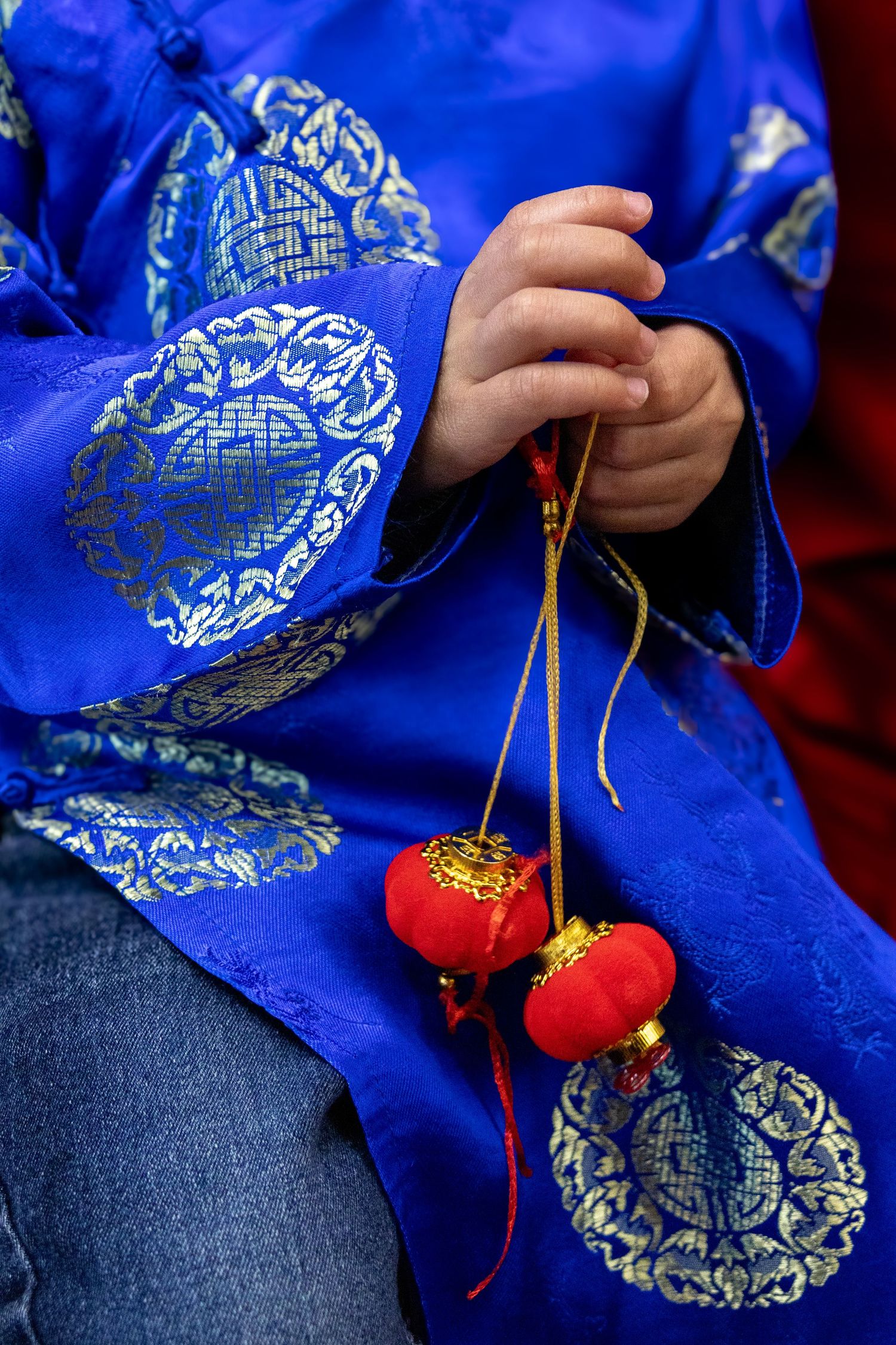 A series of close-up shots showing a bright blue Chinese silk pouch with gold patterns and red tassels.