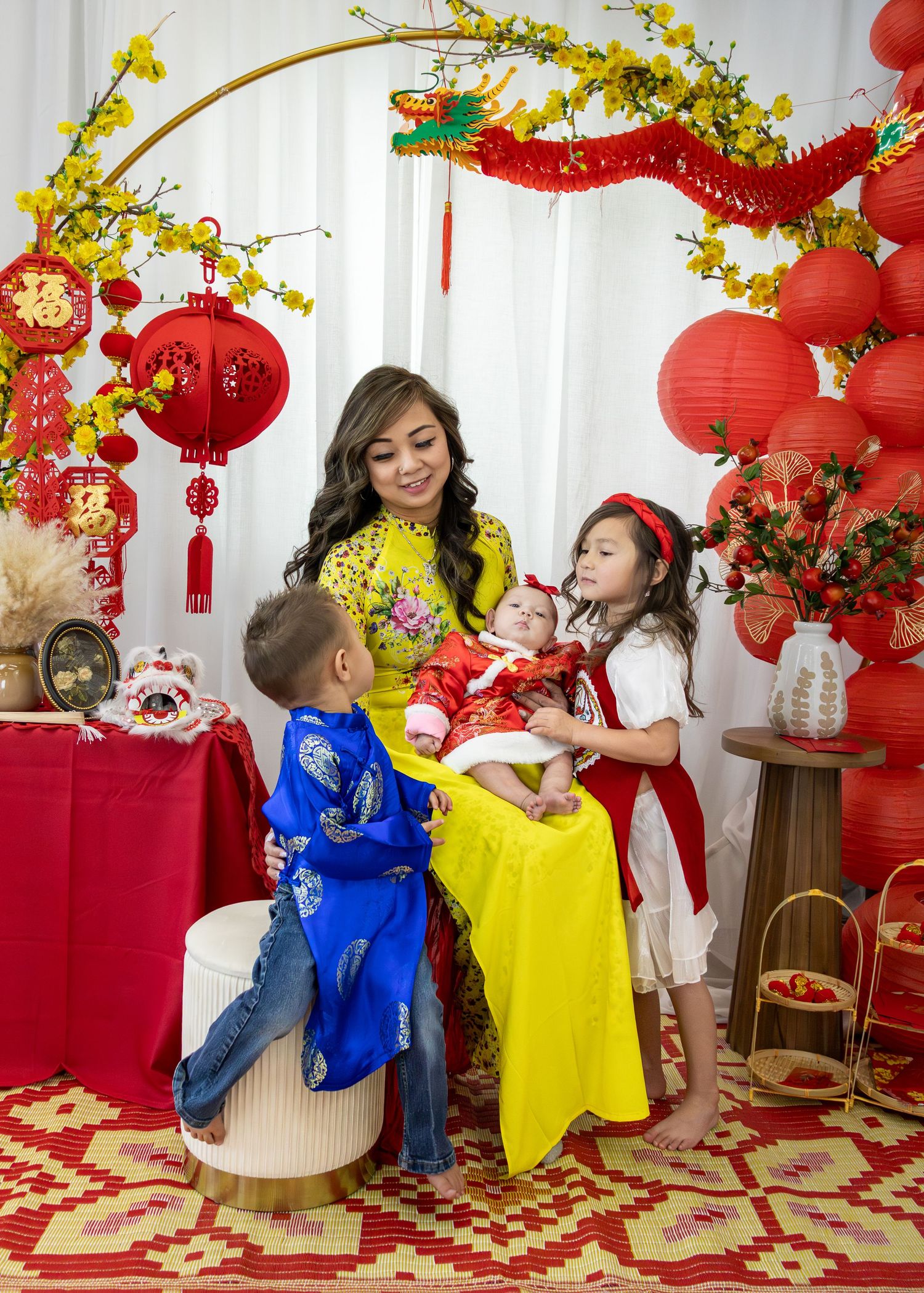 Family in traditional Vietnamese ao dai celebrating Lunar New Year with red lanterns and festive decorations.