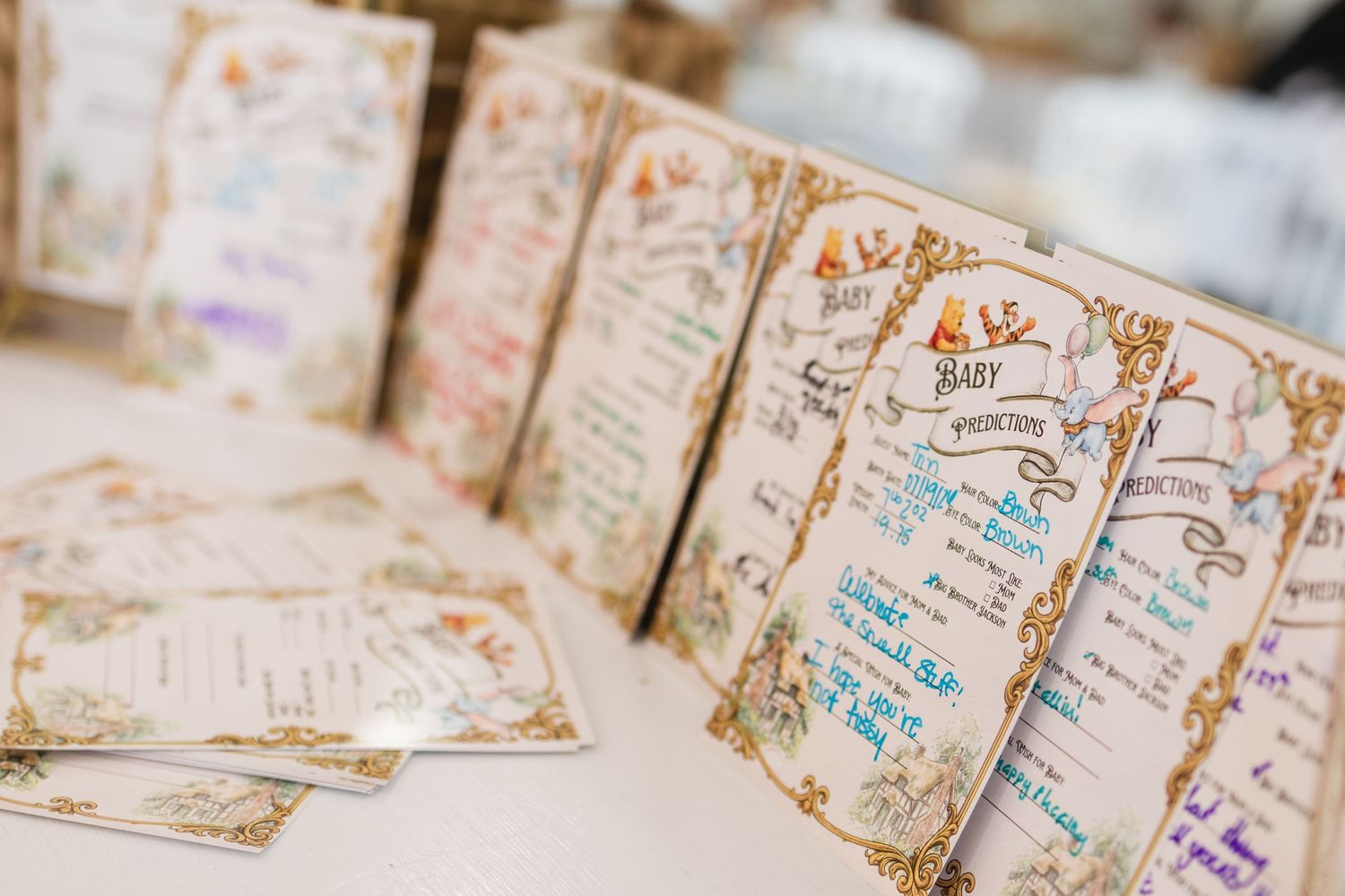 Decorative baby shower advice cards with floral borders displayed in a row on a white table.