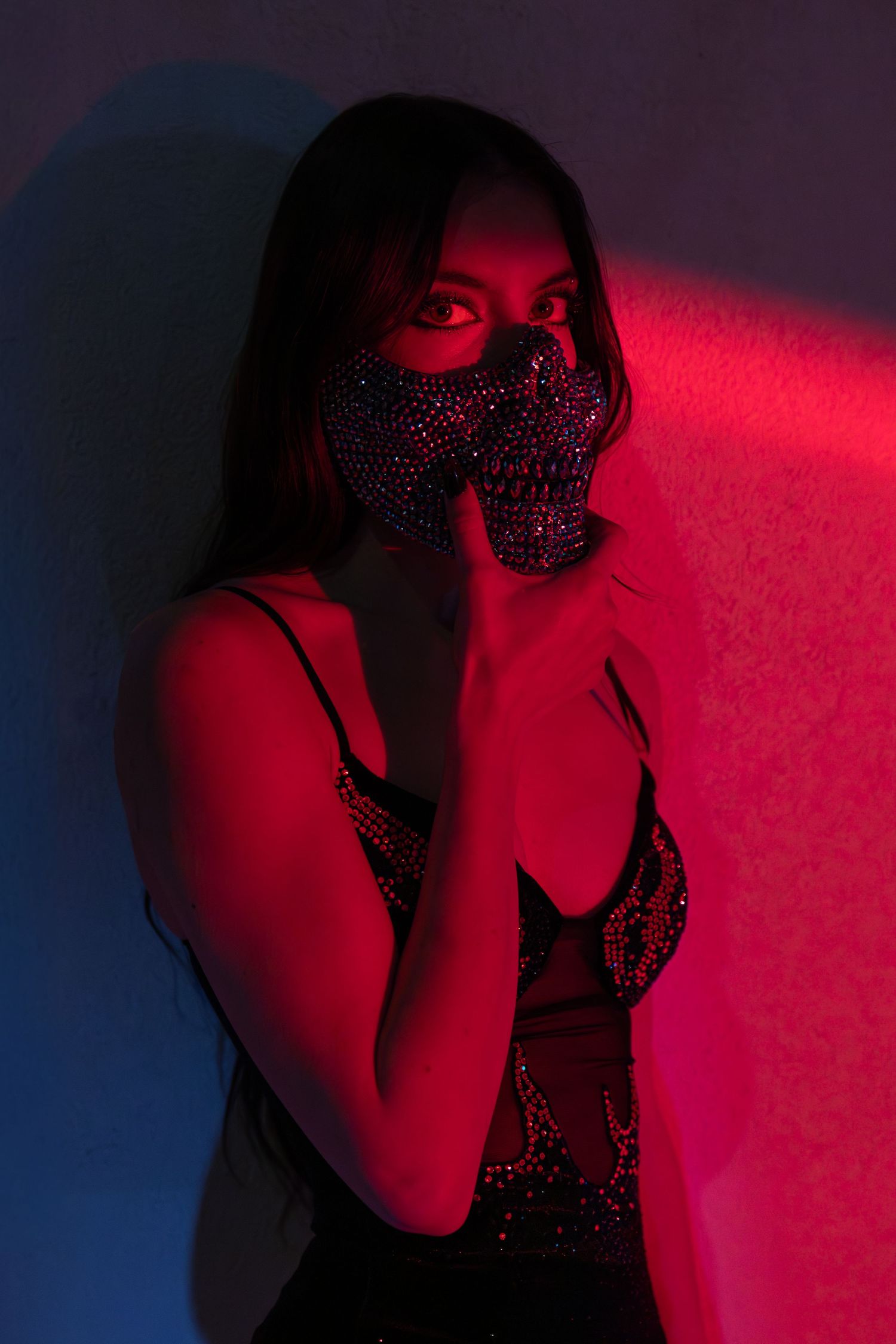 Artistic portrait series in red lighting showing silhouetted figure in sparkling dress against dark background.