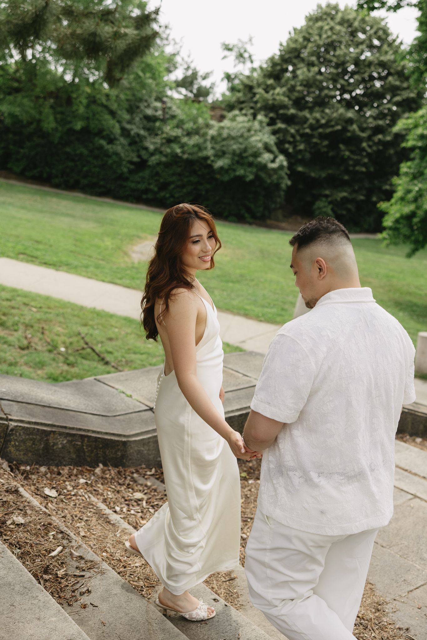 Elegant couple embracing during their engagement session at Fairmount Water Works in Philadelphia with the Schuylkill River and historic arc