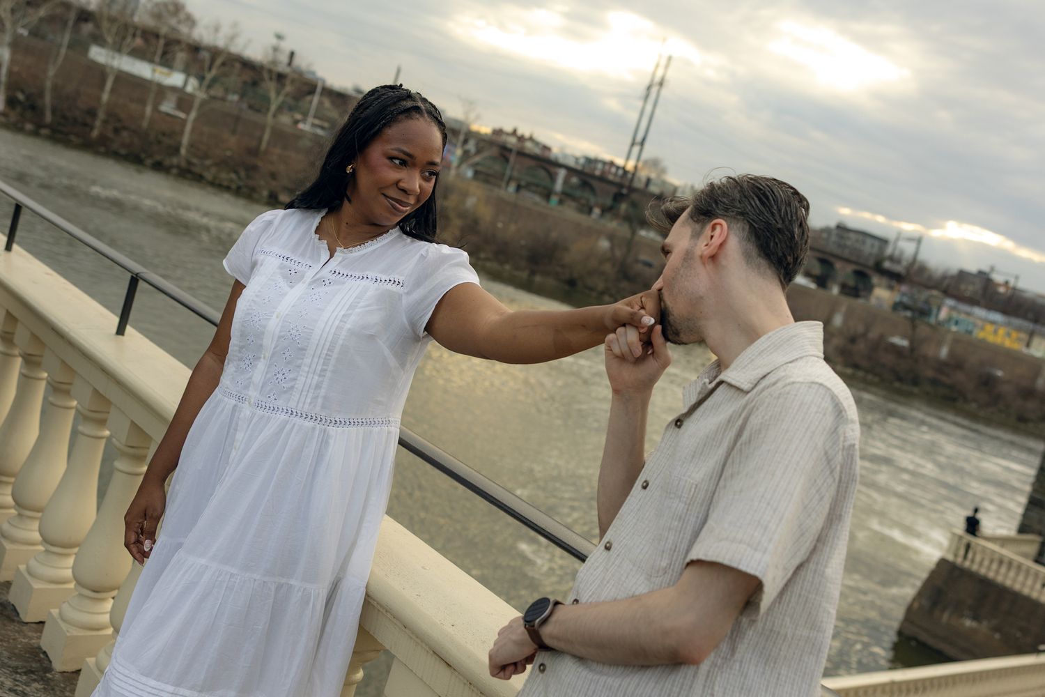Engaged couple posing at Fairmount Water Works in Philadelphia with scenic river views and historic architecture, capturing romantic moments