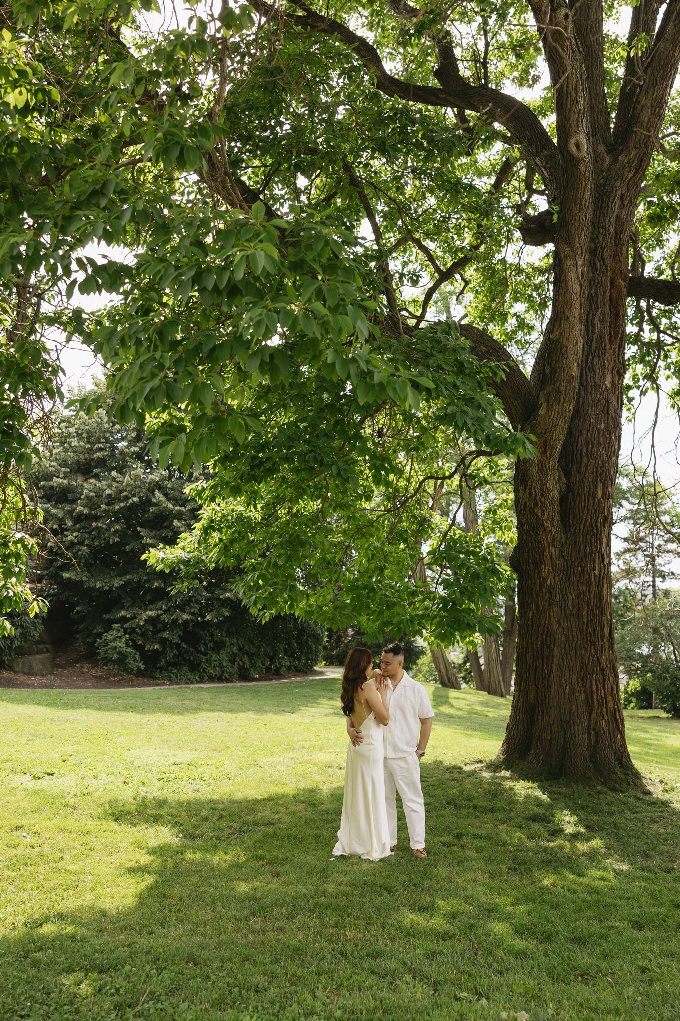 Elegant couple embracing during their engagement session at Fairmount Water Works in Philadelphia with the Schuylkill River and historic arc